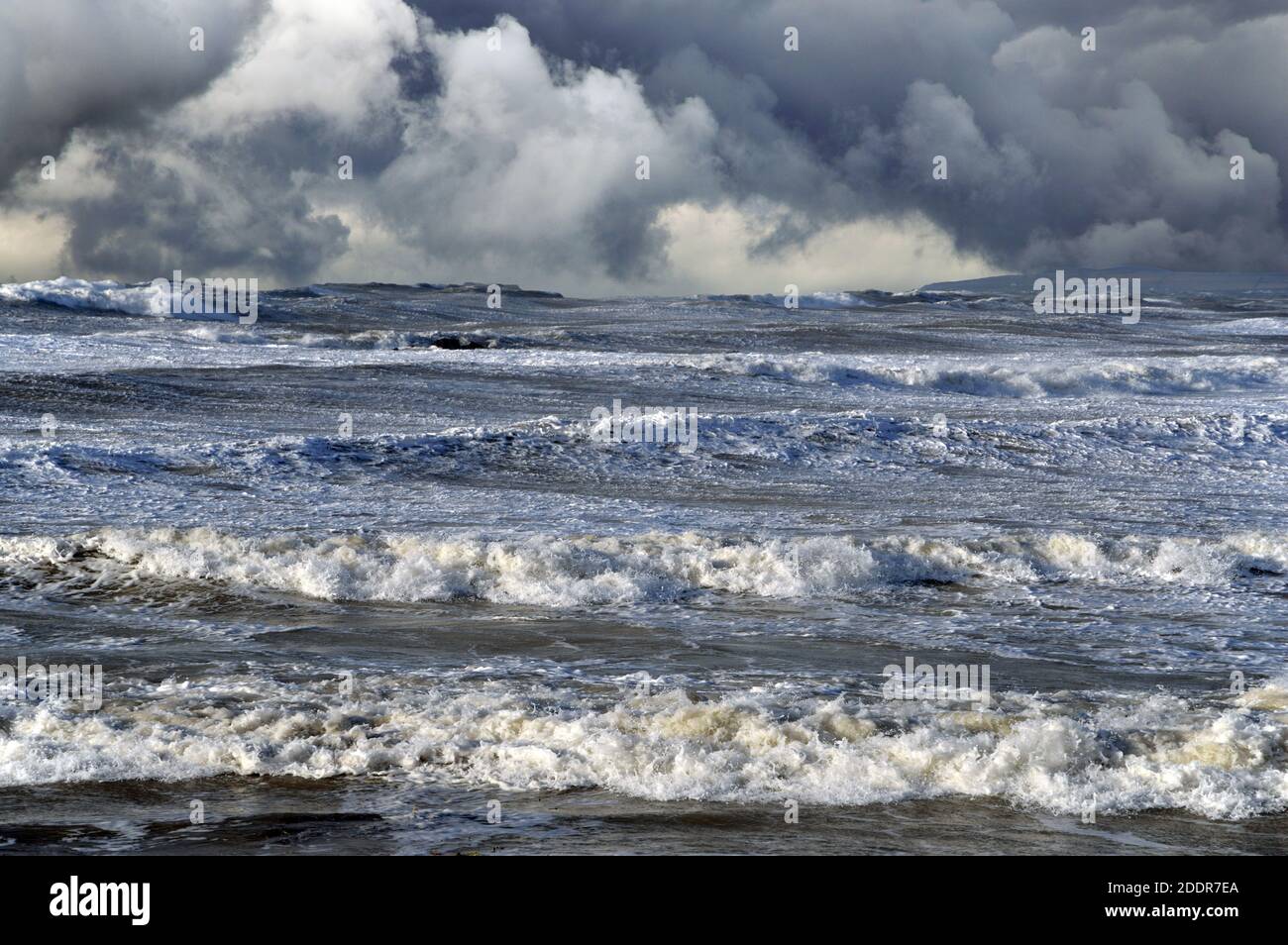 Hier sind wilde Meere in Sturmwind vor der Küste von Anglesey zu sehen. Der dramatische Himmel wurde mit Photoshop hinzugefügt. Stockfoto