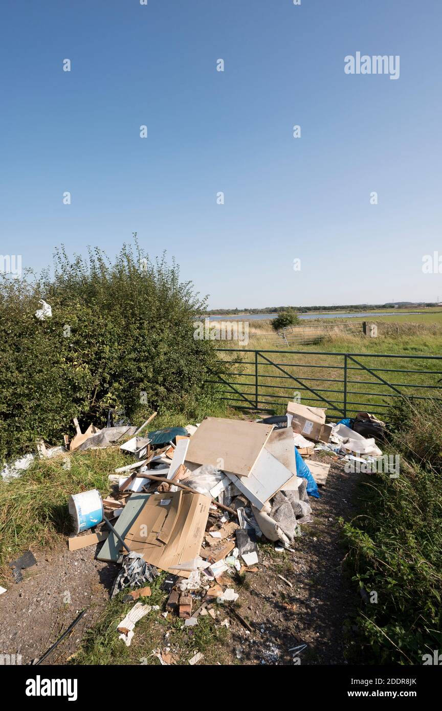 Fly kippte Müll in einem Tor zu einem Feld in der englischen Landschaft. Stockfoto