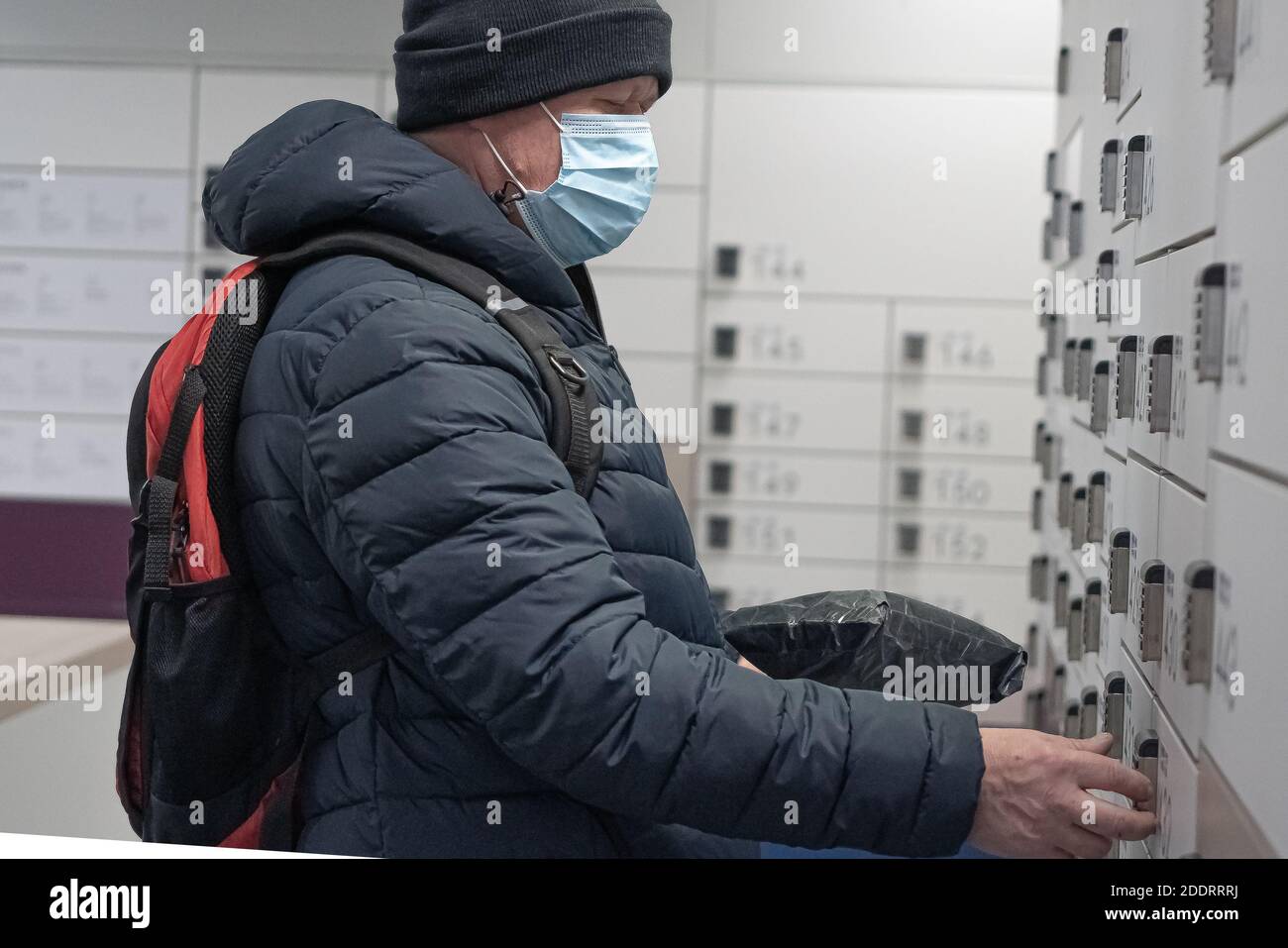 Ein Mann holt ein Paket bei der Post ab. Kontaktlos mit einer Person. Pandemiekonzept. Hochwertige Fotos Stockfoto