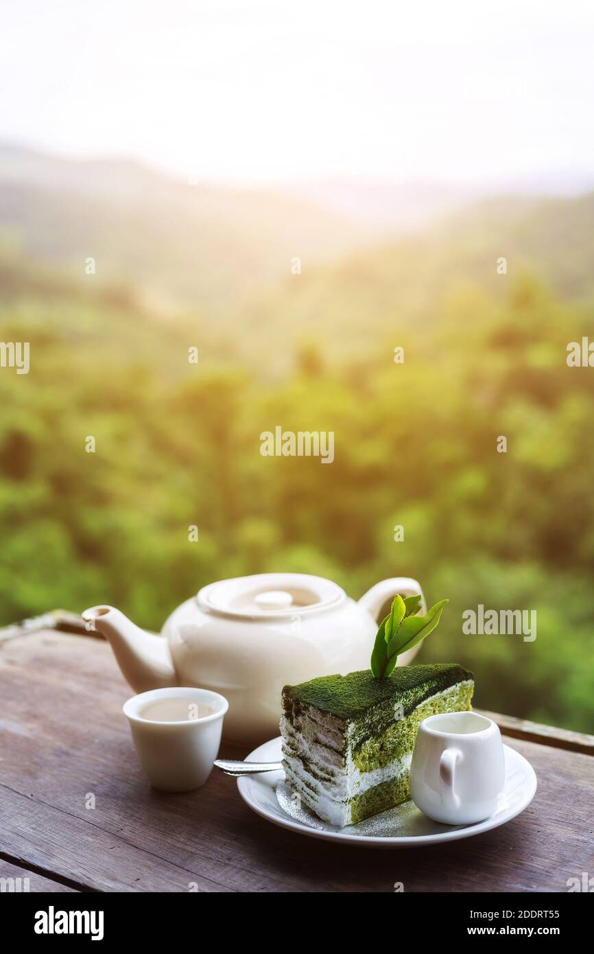 eine tasse Tee auf dem Holztisch mit wunderschönem Tee Plantage und Berg in der Morgenzeit Stockfoto