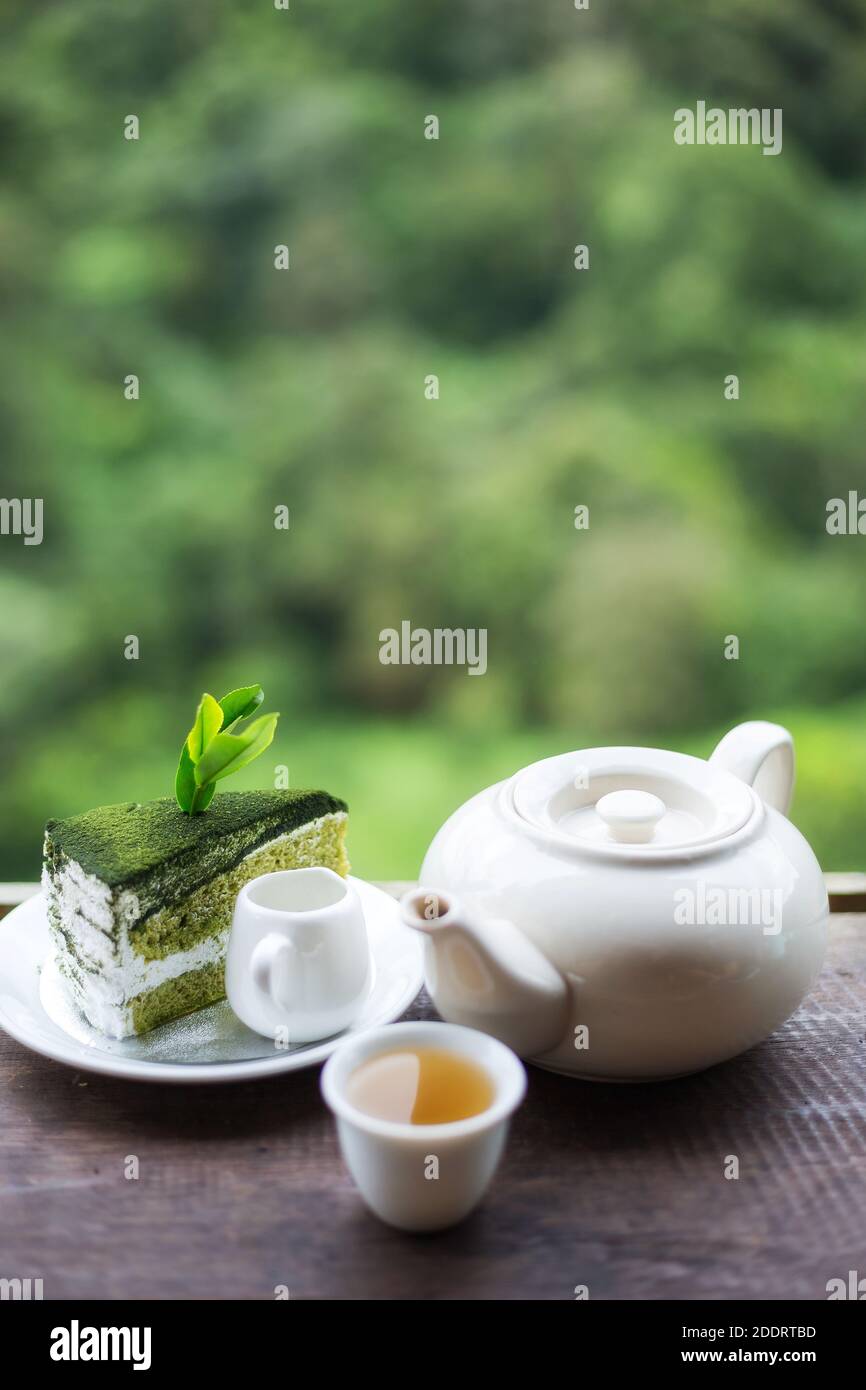 eine tasse Tee auf dem Holztisch mit wunderschönem Tee Plantage und Berg in der Morgenzeit Stockfoto
