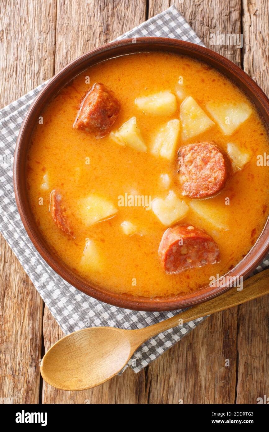 Leckere ungarische Kartoffelsuppe mit Wurst und Sauerrahm in Nahaufnahme auf einem Teller auf dem Tisch. Vertikale Draufsicht von oben Stockfoto
