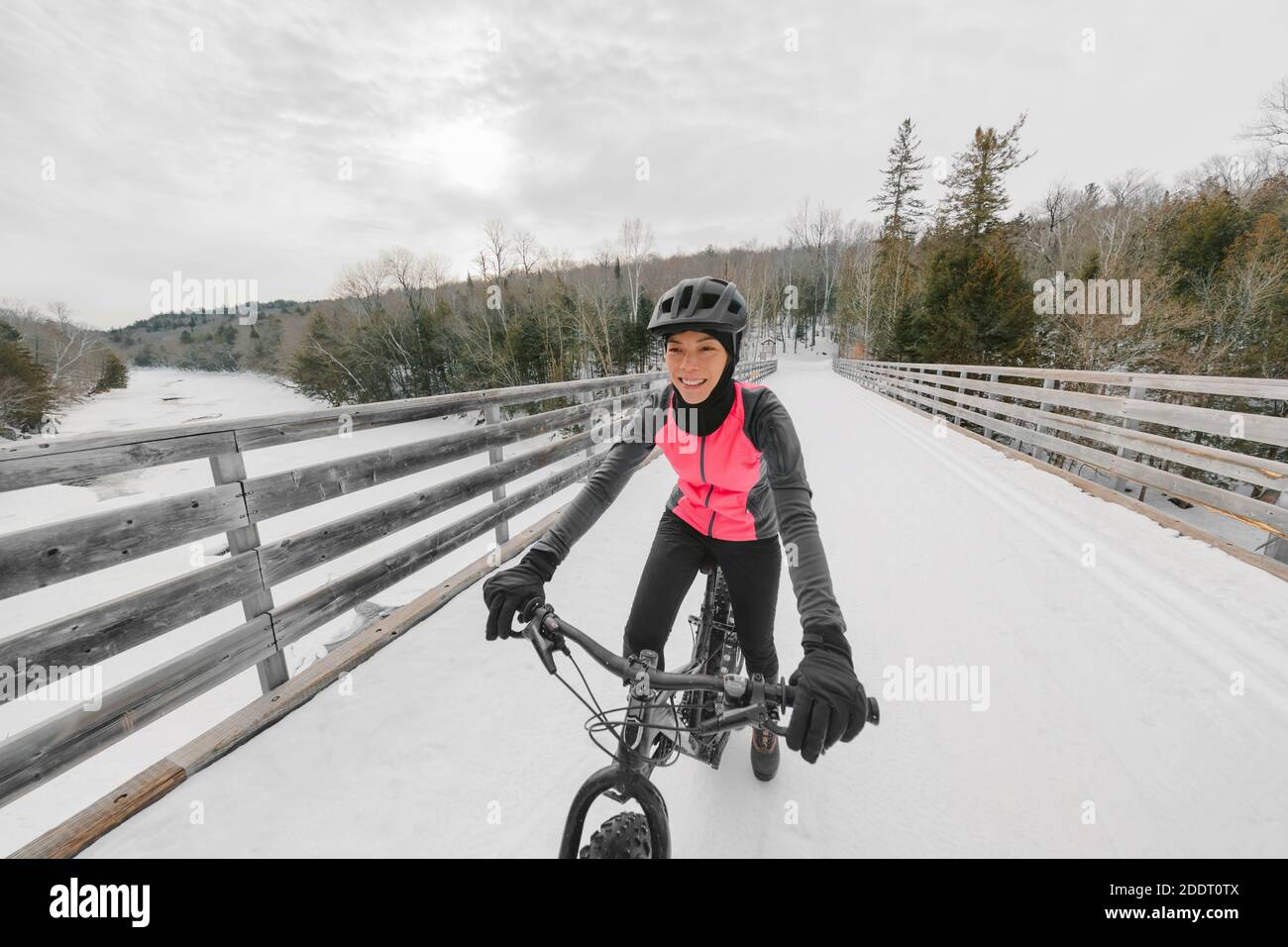 Winter Fahrrad Sport Spaß glücklich Radfahrer Asiatische Mädchen Radfahren auf Schneebrücke mit Fett E-Bike. Elektrofahrrad Stockfoto