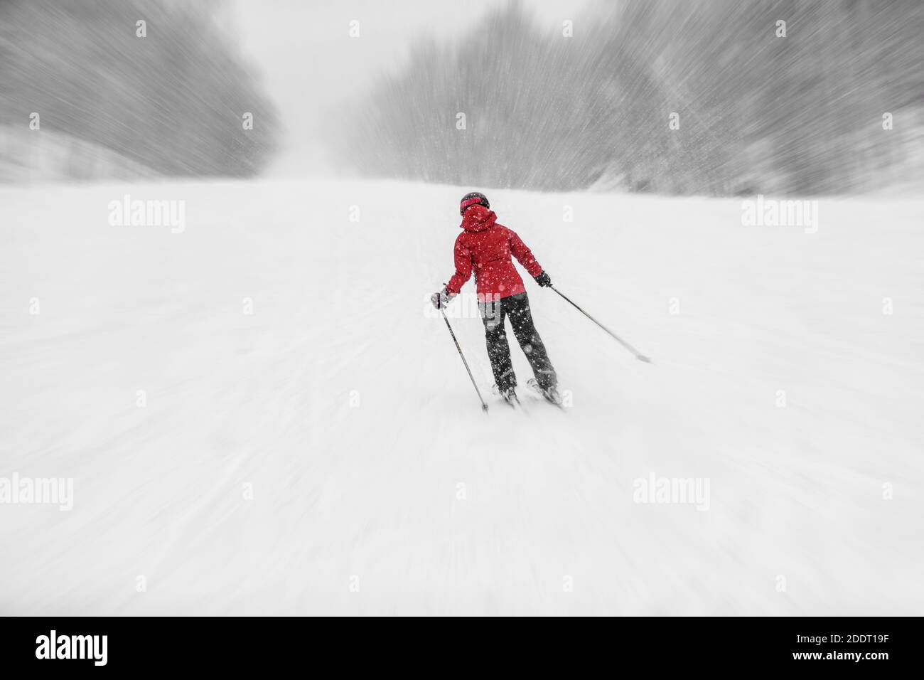 Skifahren Alpinski während des Schneesturms. Frau Athlet Reiten schneebedeckten Hang bei kaltem Wetter whiteout. Winter Snowsport Stockfoto