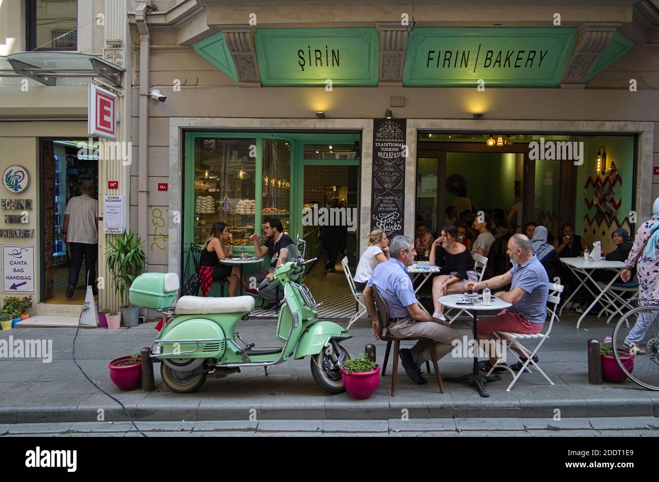 Istanbul, Türkei - September, 2018: Leute, die Tee und Kaffee außerhalb des Cafés auf der Straße trinken. Zwei Männer reden und trinken Tee. Alte alte Jahrgang motorcycl Stockfoto