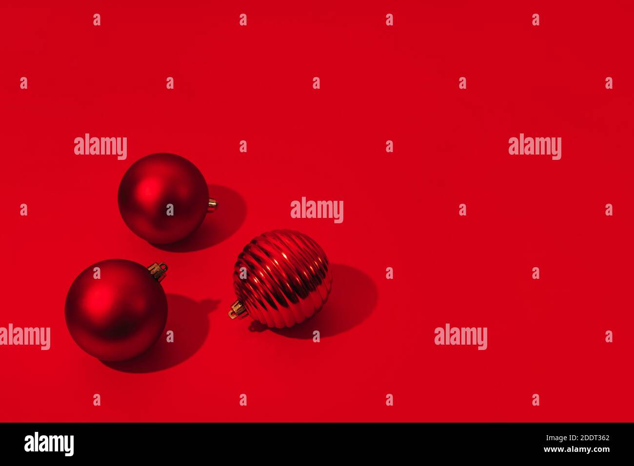 Weihnachten und Neujahr rote Bälle mit Kopierplatz auf rotem Hintergrund. Hartes Licht. Stockfoto