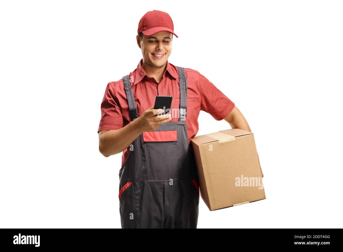 Männlicher Kurier in einer Uniform, der eine Schachtel hält und schreibt Auf einem Mobiltelefon, das auf weißem Hintergrund isoliert ist Stockfoto