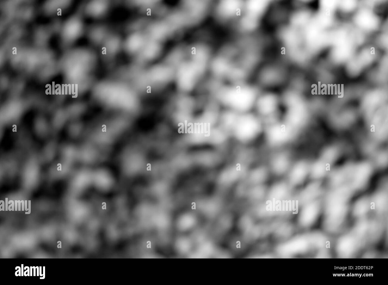 Defokussierter abstrakter Szenenhintergrund in grauer Textur mit Stein, Kies und Zement in Licht und Schatten Stockfoto