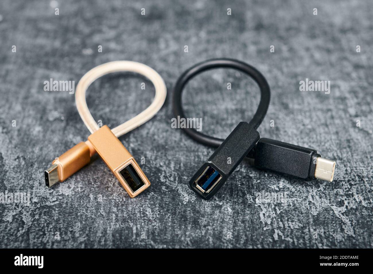 Zwei USB-Kabel Typ A bis Typ C, kompatibel für viele Geräte, auf grauem Hintergrund, geringe Schärfentiefe Stockfoto
