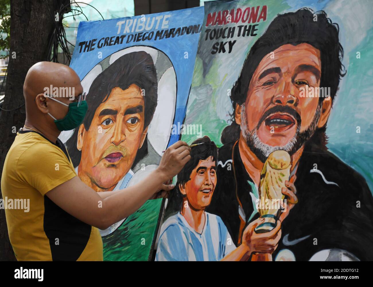 Ein Künstler sah, wie er ein Graffiti des Fußballspielers Diego Maradona zum letzten Mal berührte.der ehemalige argentinische Fußballspieler Diego Maradona starb wegen eines Herzinfarkts in seinem Haus. Stockfoto