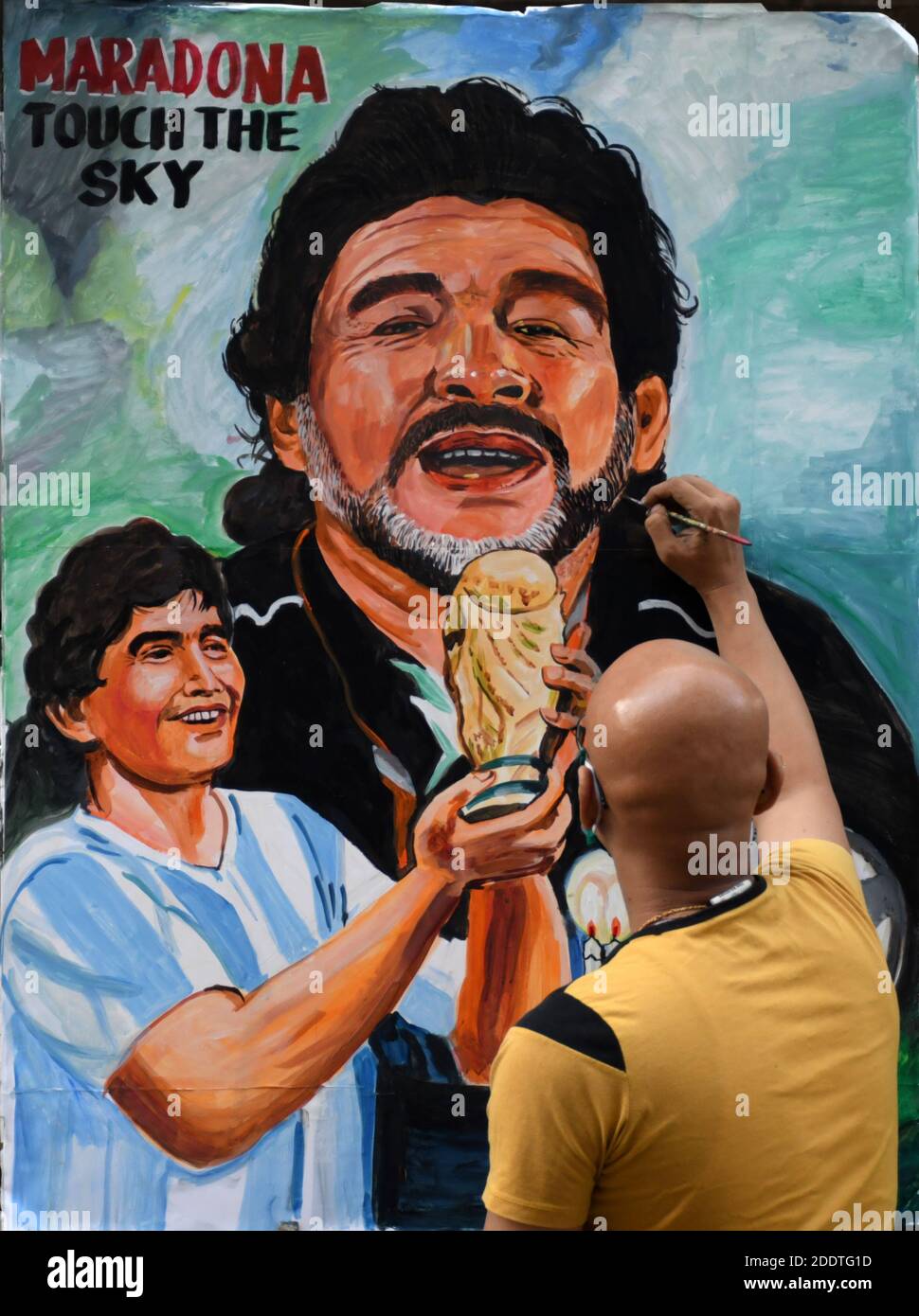 Ein Künstler sah, wie er ein Graffiti des Fußballspielers Diego Maradona zum letzten Mal berührte.der ehemalige argentinische Fußballspieler Diego Maradona starb wegen eines Herzinfarkts in seinem Haus. Stockfoto