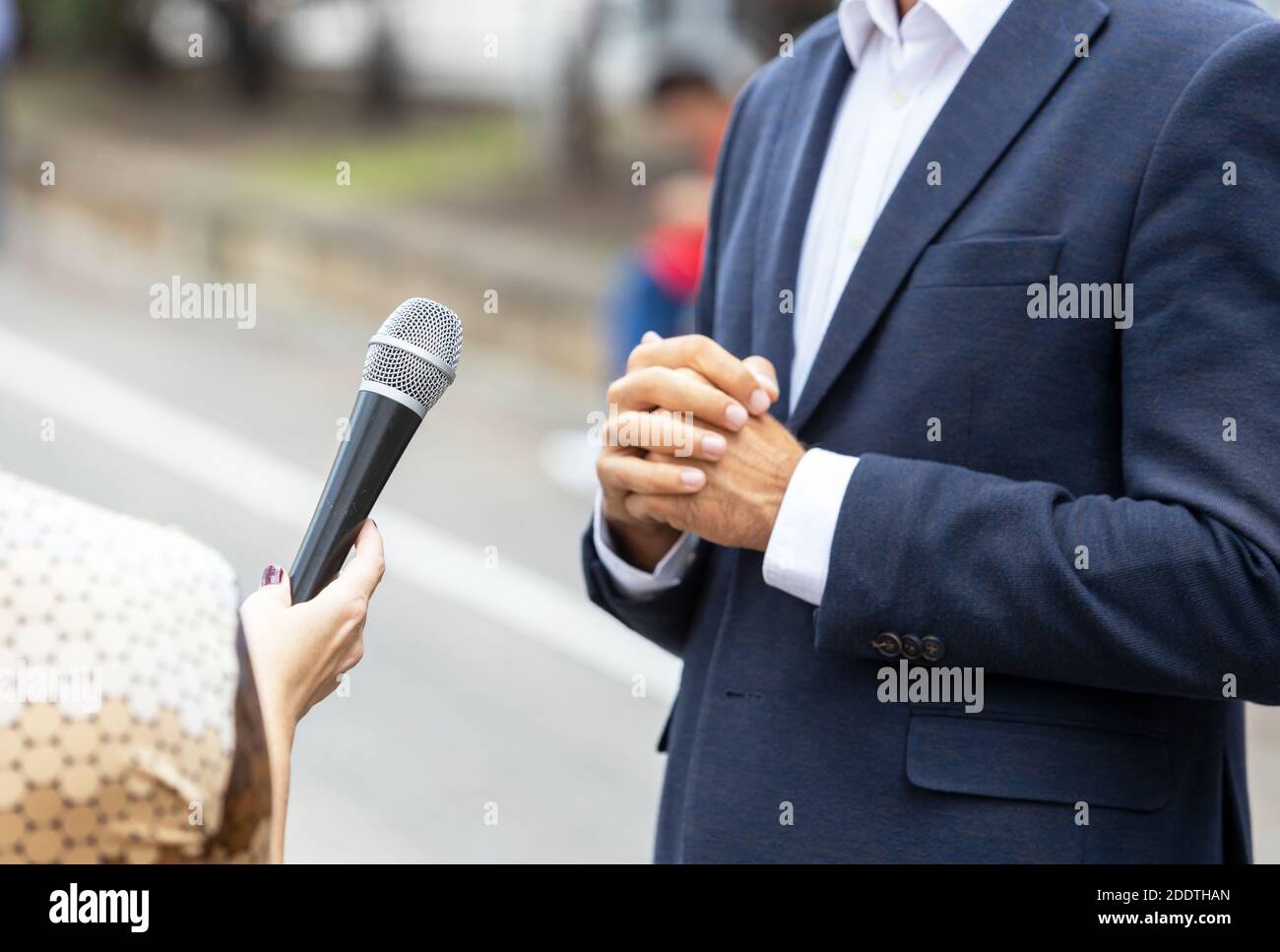 Reporter, der ein Presseinterview mit einer nicht erkennbaren Person macht. Vox populi Konzept. Stockfoto