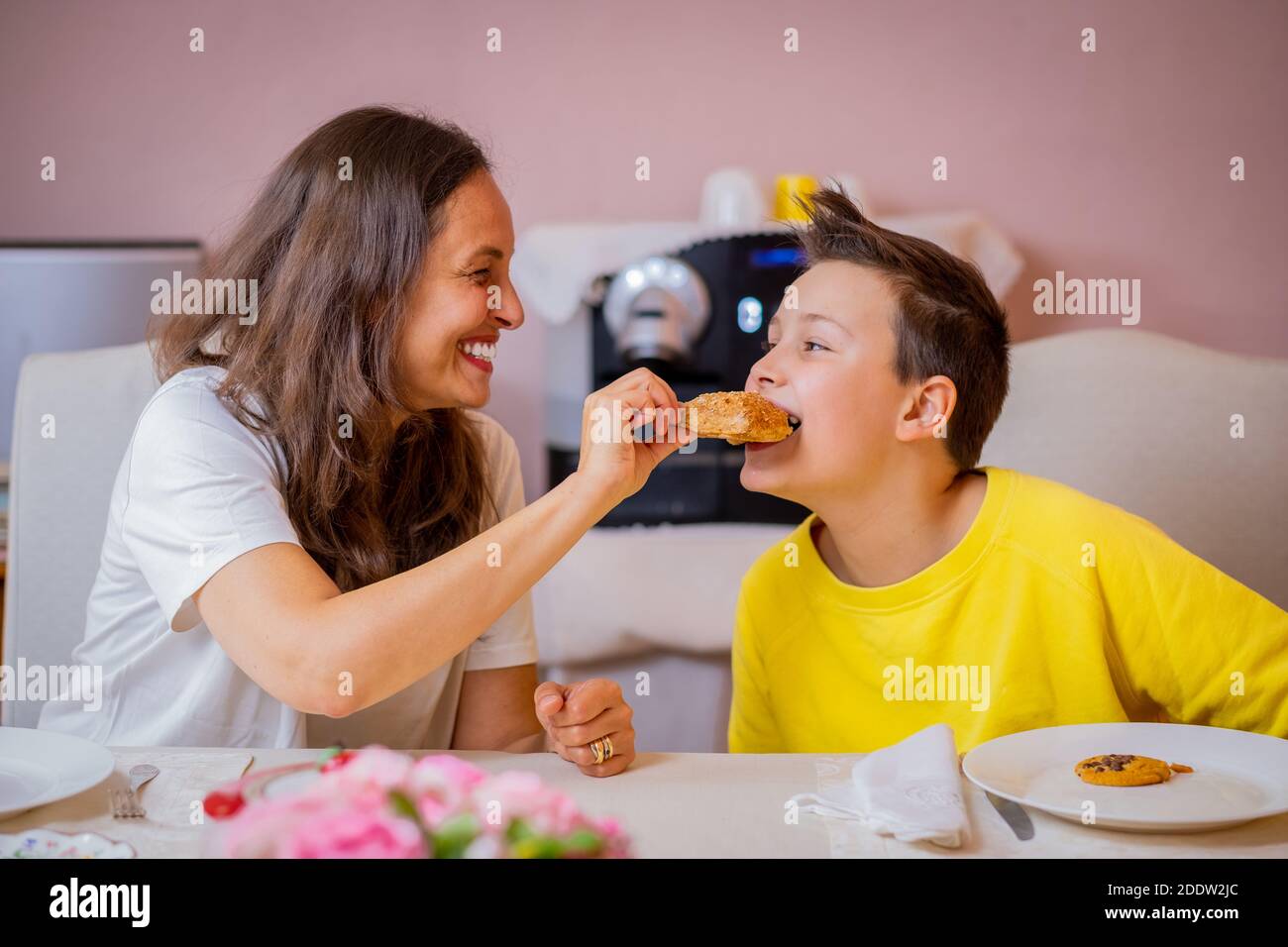 Mama und Sohn frühstücken und schauen sich gegenseitig an - Mädchen Mutter und Sohn beim Frühstück zusammen Stockfoto