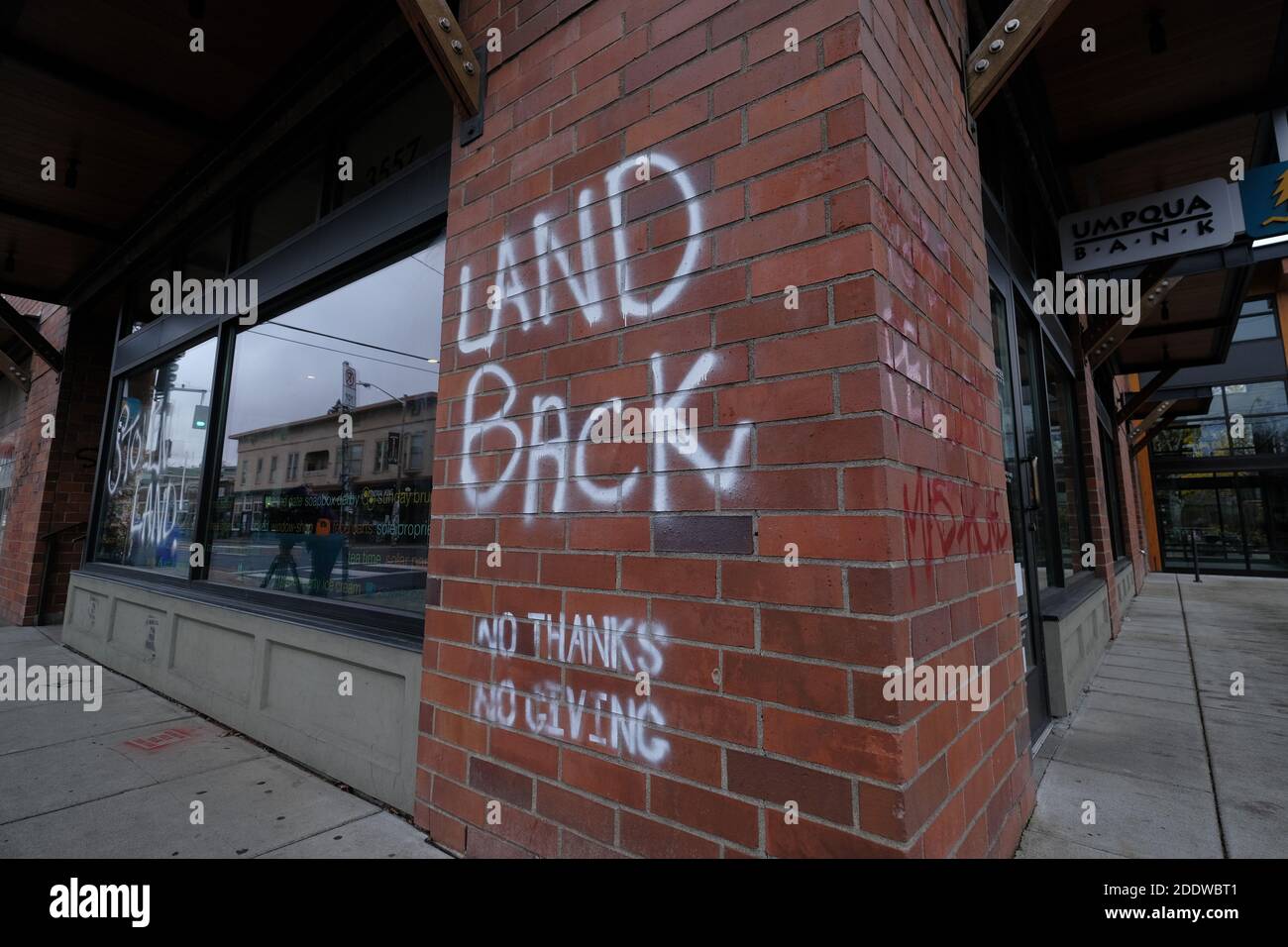Portland, USA. November 2020. "Land Back"-Graffiti ist auf dem Fenster der Umpqua Bank in der Southeast Hawthorne Street in Portland, Oregon, am 26. November 2020 abgebildet, nach einem Aufruf zum Handeln am Thanksgiving-Abend, der indigene Demonstranten dazu aufforderte, Symbole des Kolonialismus, des Kapitalismus und der Gentrifizierung anzugreifen. (Foto: Alex Milan Tracy/Sipa USA) Quelle: SIPA USA/Alamy Live News Stockfoto
