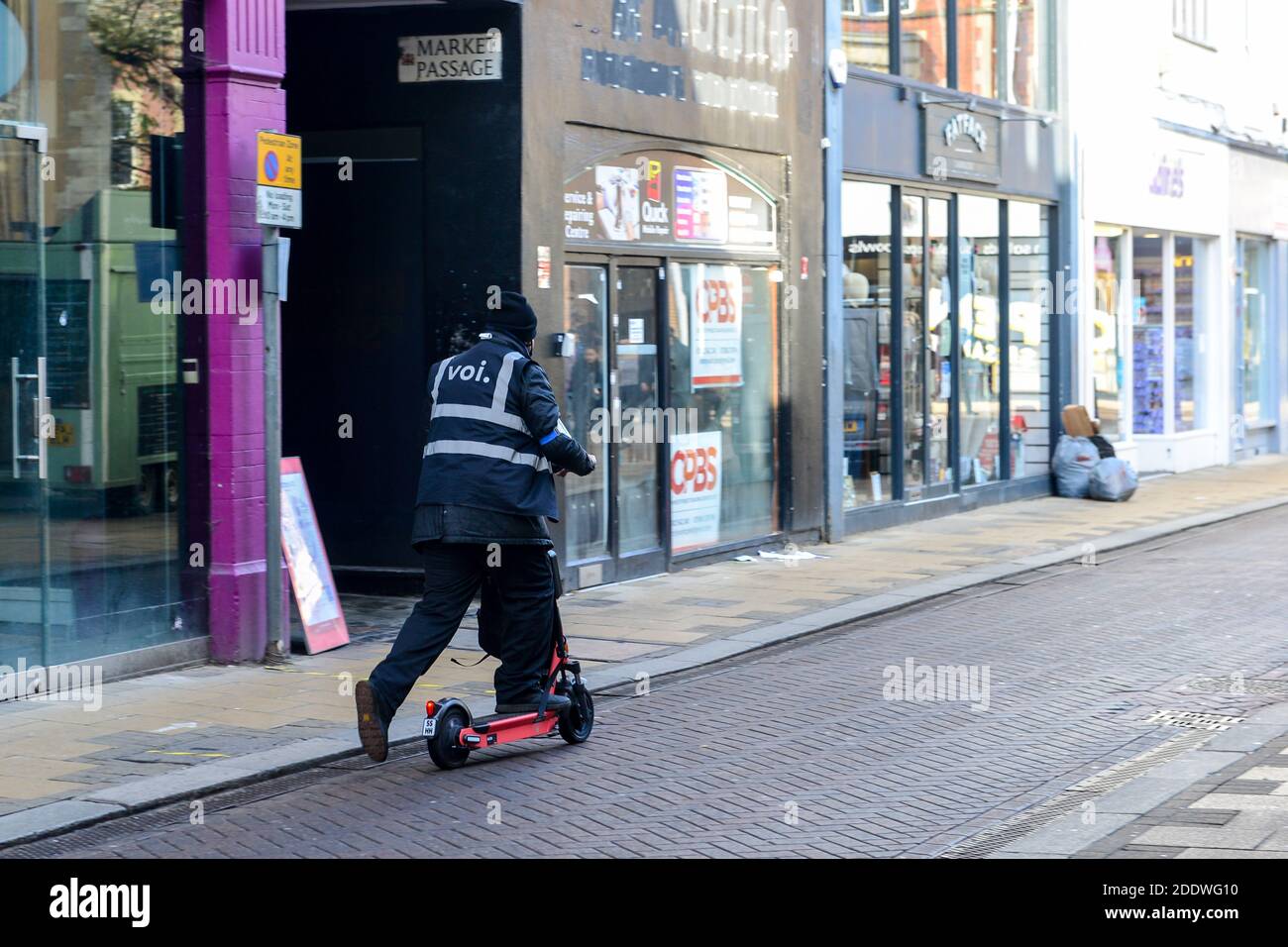 Cambridge UK, England , 07-11-2020. VOI Sccooter Mitarbeiter Roller zum lizenzierten Parkplatz bewegen. Die VOI-Scooter werden in der Stadt als Ca Stockfoto