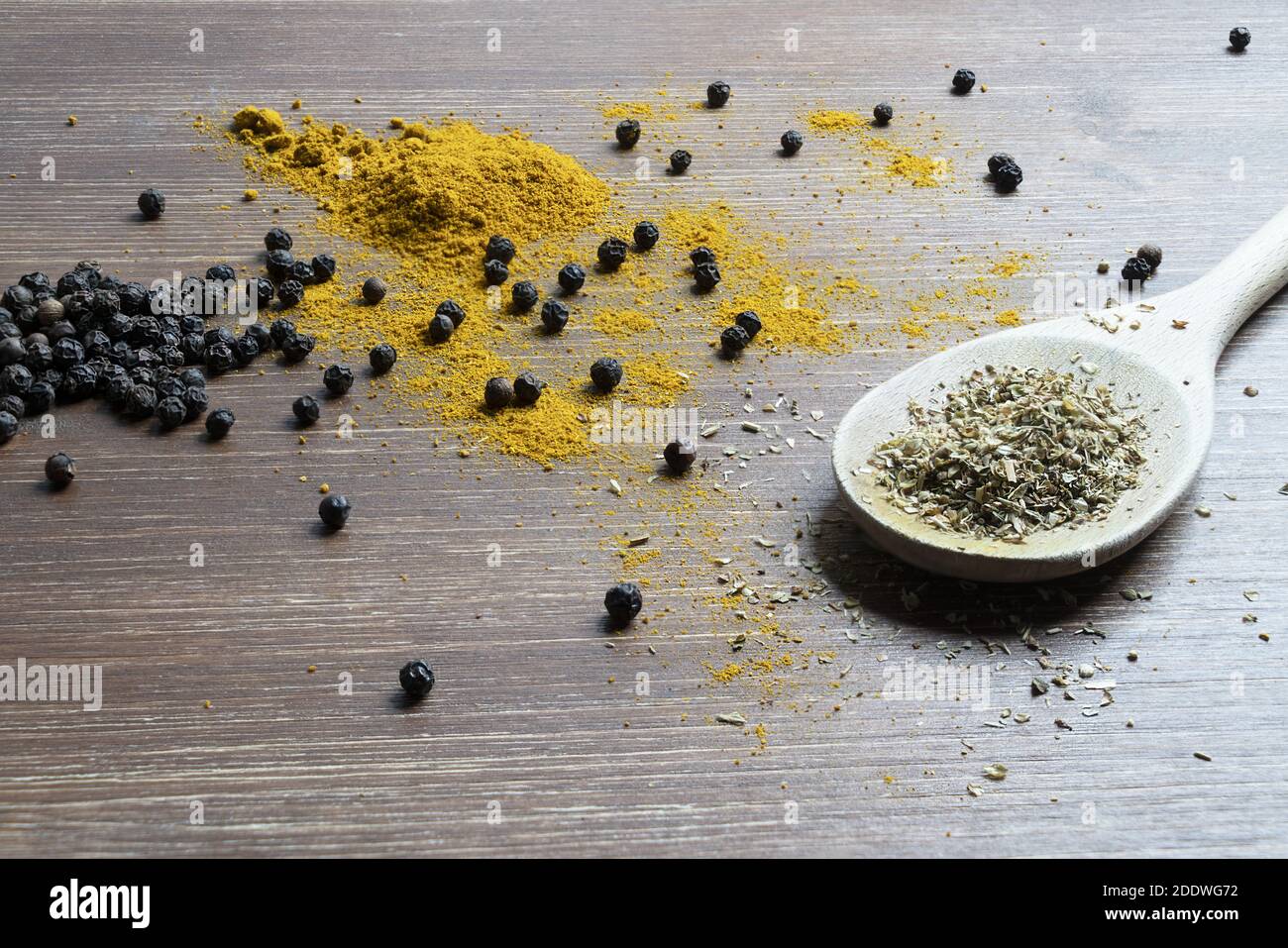 Eine Holzpfanne mit Currypulver und Pfefferkörner Stockfoto