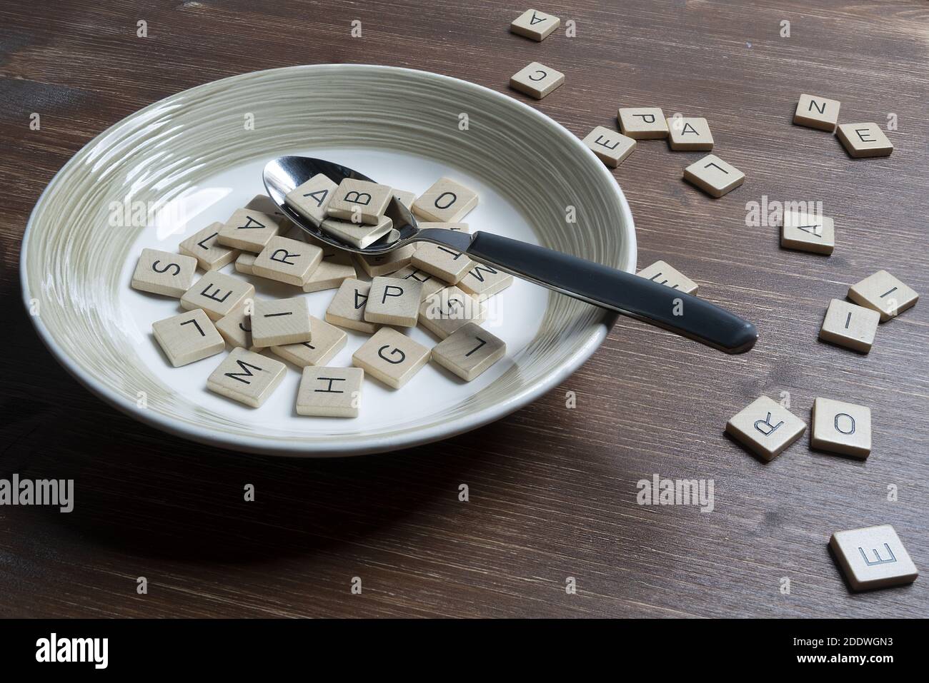 Ein Teller voller Buchstaben auf einem Holztisch Stockfoto