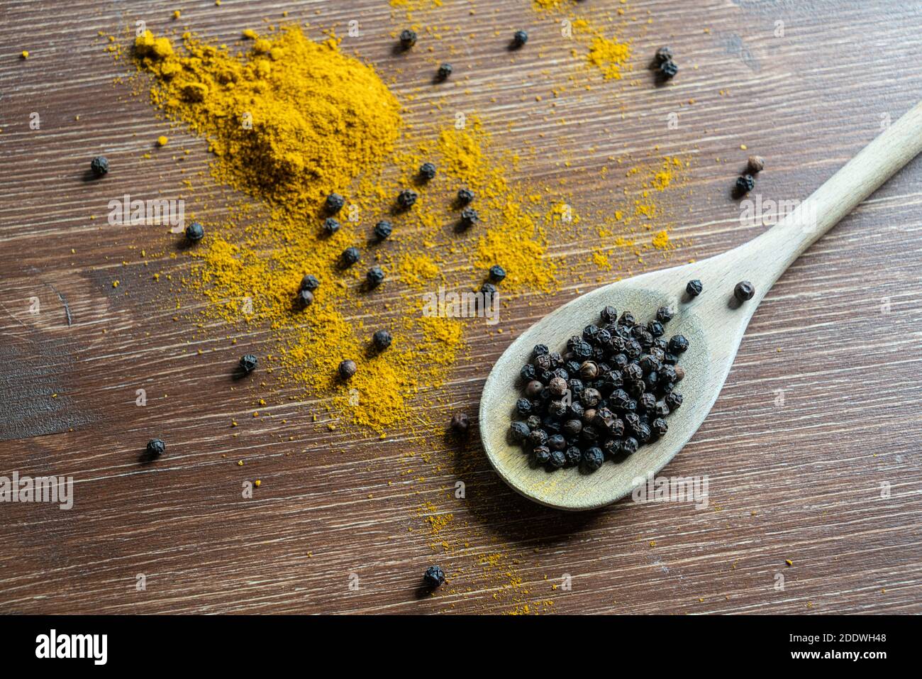 Eine Holzpfanne mit Currypulver und Pfefferkörner Stockfoto