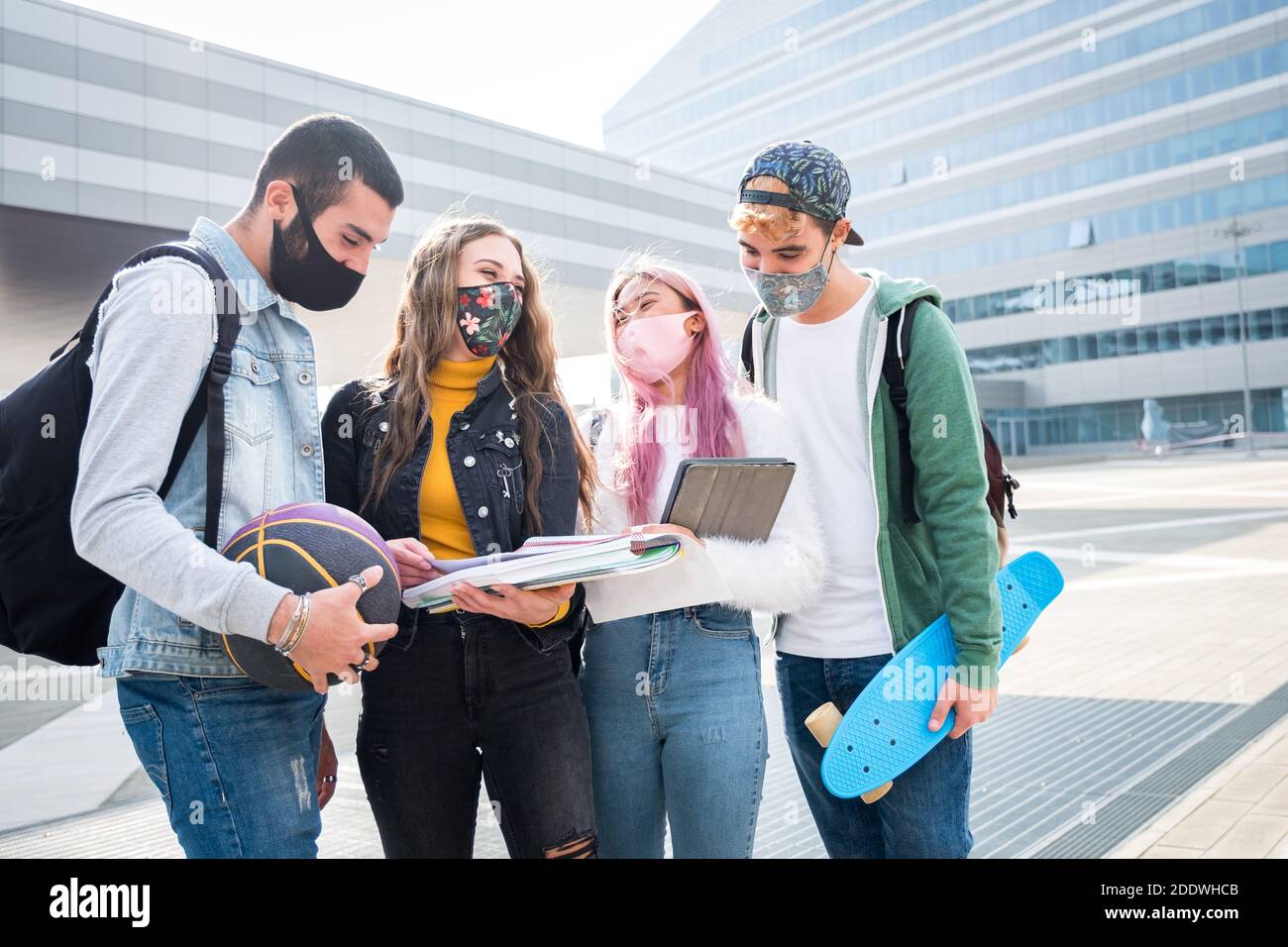 Multirassische Studenten mit Gesichtsmaske studieren am College-Campus - Neues normales Lifestyle-Konzept mit jungen Schülern, die gemeinsam Spaß haben Im Freien Stockfoto