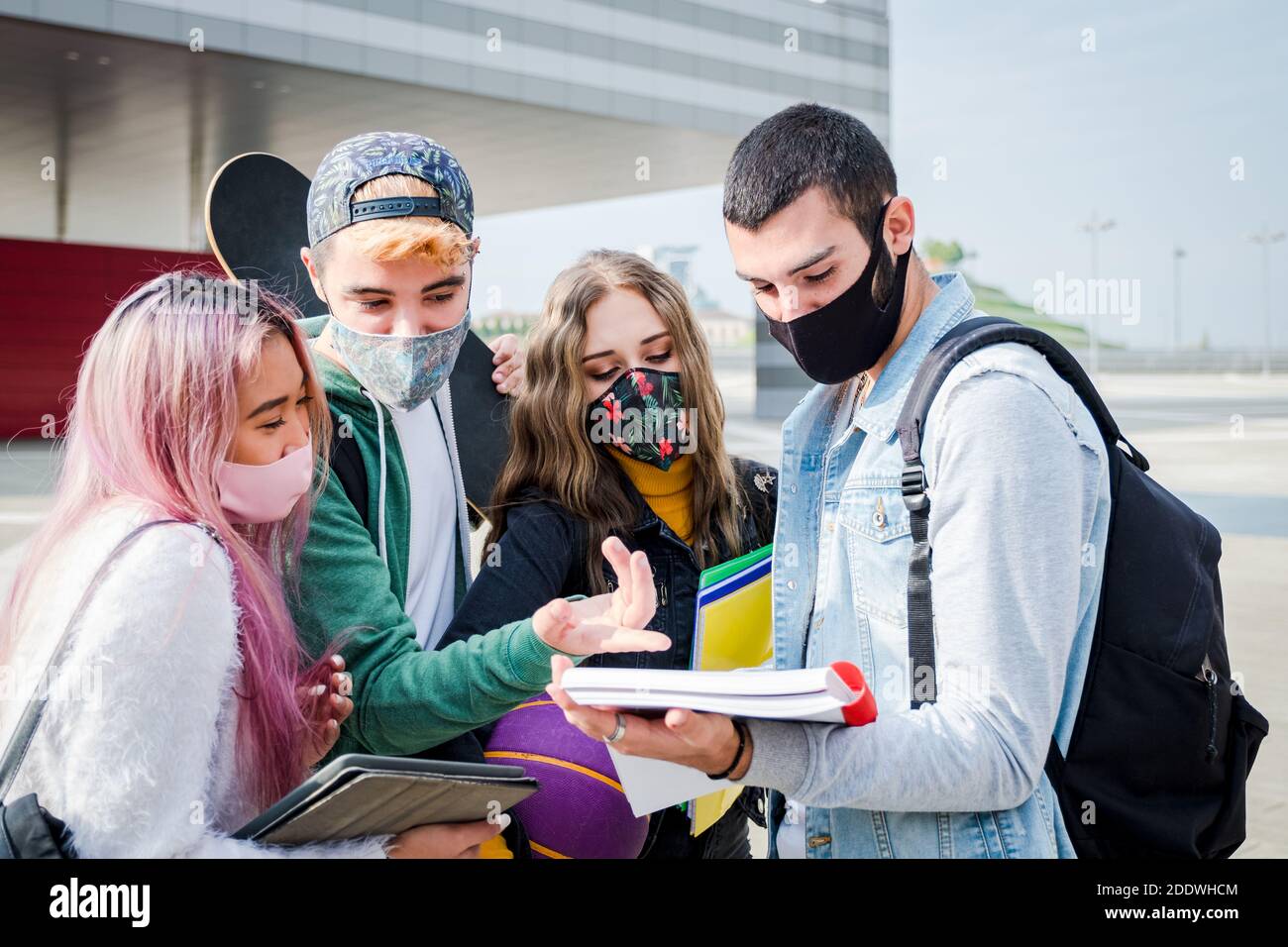 Multirassische Studenten mit Gesichtsmaske studieren am College-Campus - Neues normales Lifestyle-Konzept mit jungen Schülern, die gemeinsam Spaß haben Im Freien Stockfoto