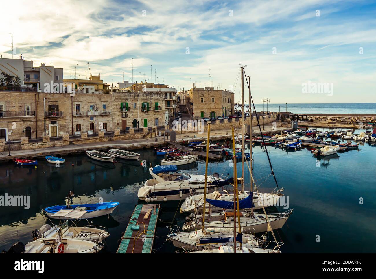 Kleiner Hafen in Giovinazzo in der Nähe von Bari mit bunten Fischerbooten. Befestigte Altstadt direkt am Meer.Apulien/Apulien Südostitalien. Stockfoto