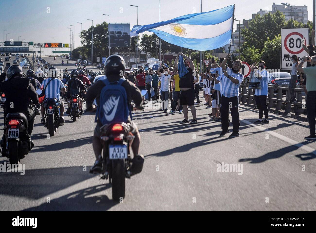 Buenos Aires, Argentinien. November 2020. Fans winken die Flagge Argentiniens, während der Leichenwagen, der die Überreste von Diego Maradona trägt, sie auf dem Weg zum Friedhof passiert. Maradona starb am Vortag im Alter von 60 Jahren. Kredit: Fernando Gens/dpa/Alamy Live Nachrichten Stockfoto