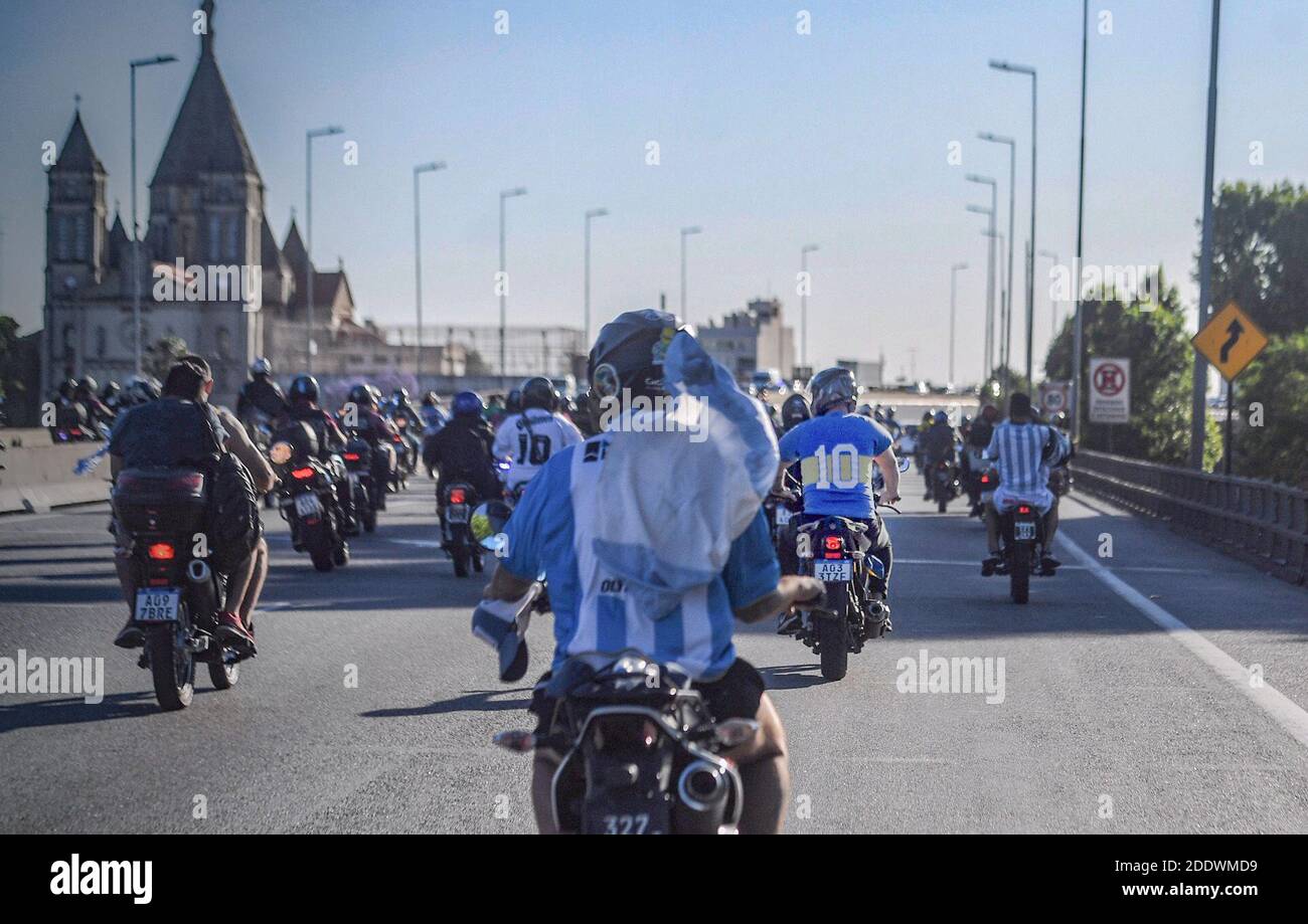 Buenos Aires, Argentinien. November 2020. Fans in Trikots der argentinischen Nationalmannschaft, des Fußballclubs Boca Juniors und Flaggen fahren hinter dem Leichenwagen mit den Resten von Diego Maradona, die zu einem Friedhof im Vorort Bella Vista gefahren werden. Maradona starb am Vortag im Alter von 60 Jahren. Kredit: Fernando Gens/dpa/Alamy Live Nachrichten Stockfoto
