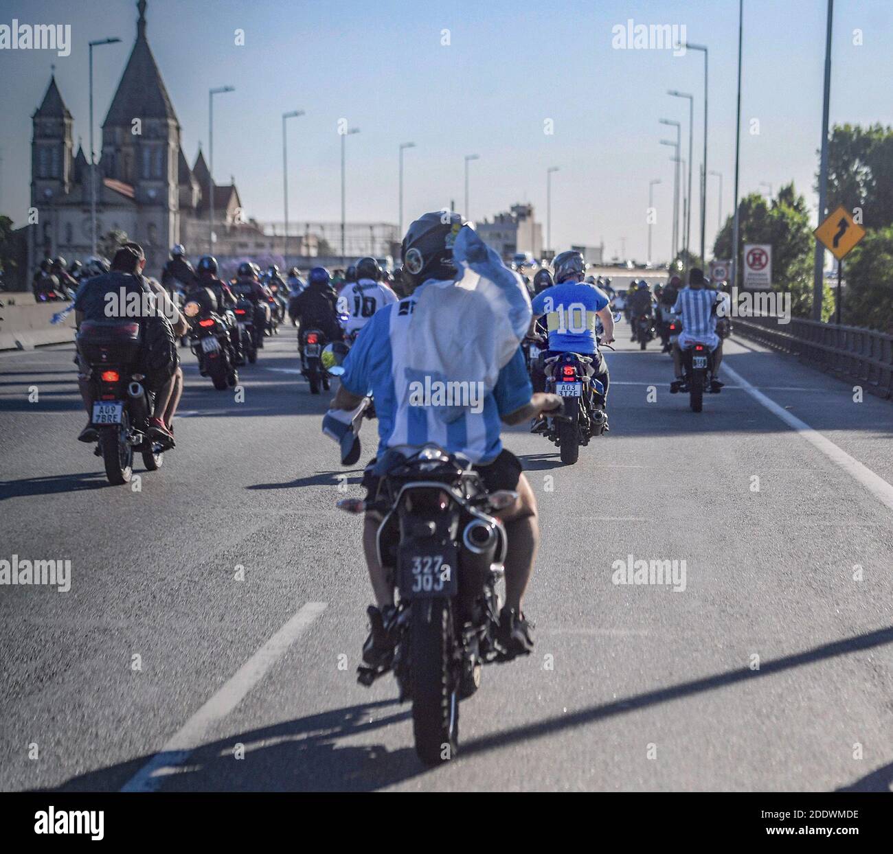 Buenos Aires, Argentinien. November 2020. Fans in Trikots der argentinischen Nationalmannschaft, des Fußballclubs Boca Juniors und Flaggen fahren hinter dem Leichenwagen mit den Resten von Diego Maradona, die zu einem Friedhof im Vorort Bella Vista gefahren werden. Maradona starb am Vortag im Alter von 60 Jahren. Kredit: Fernando Gens/dpa/Alamy Live Nachrichten Stockfoto