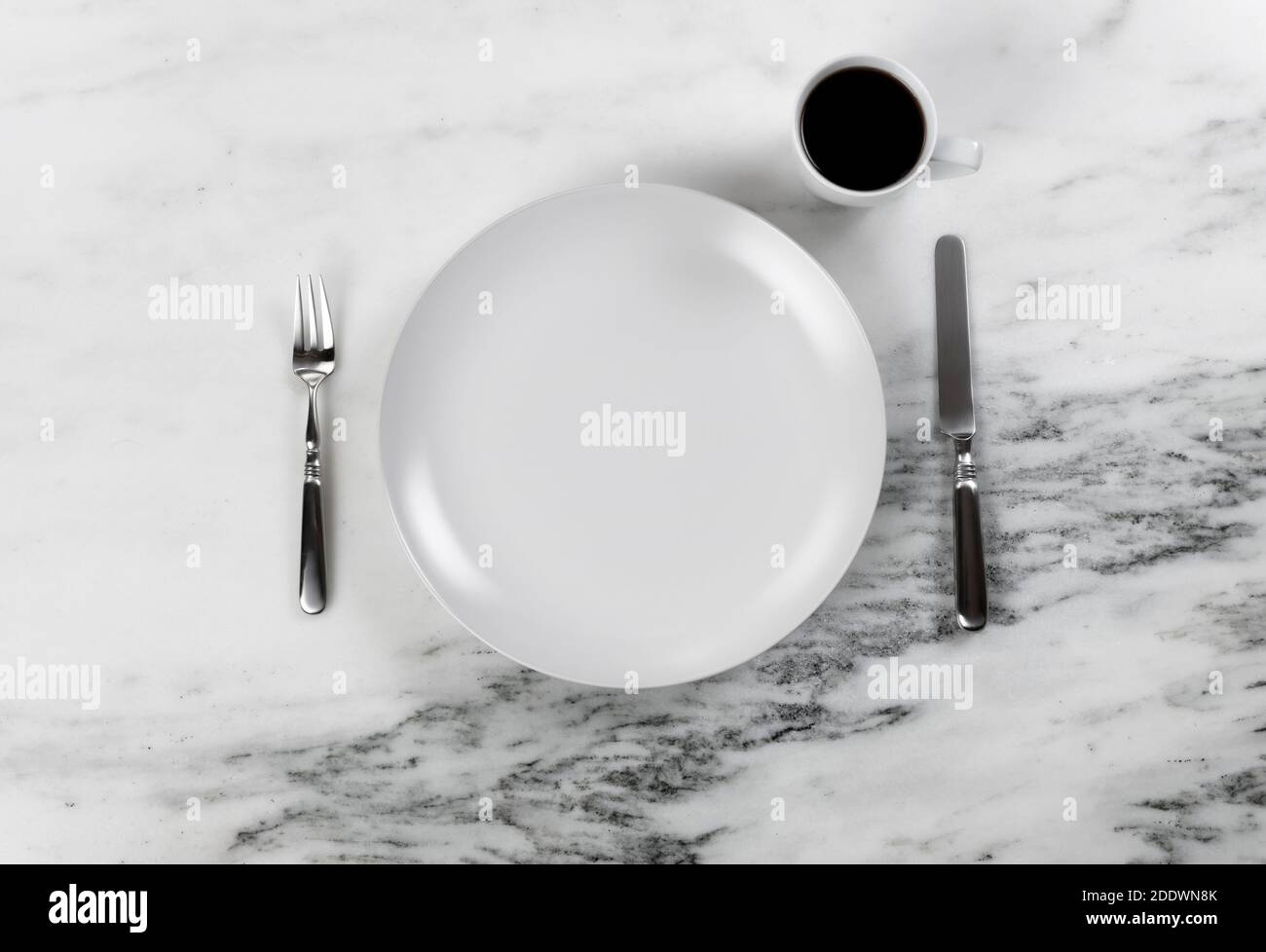 Kaffeegetränk plus Dinner-Setting mit sauberem Teller, Messer und Gabel auf Marmortisch Stockfoto