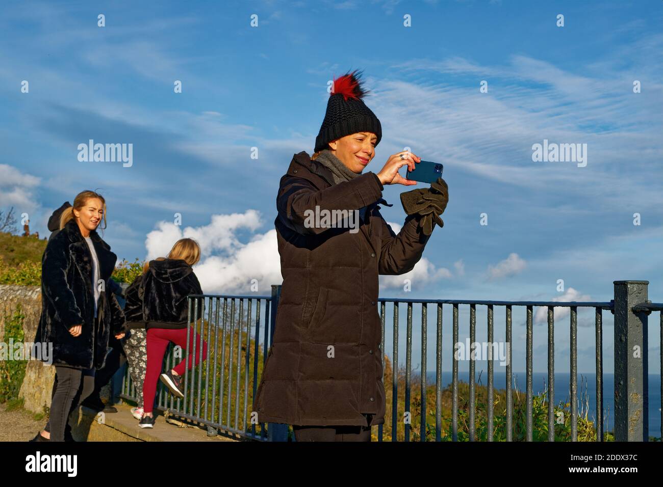 Frau in Beanie nimmt Smartphone Selfie im Herbst Park Stockfoto