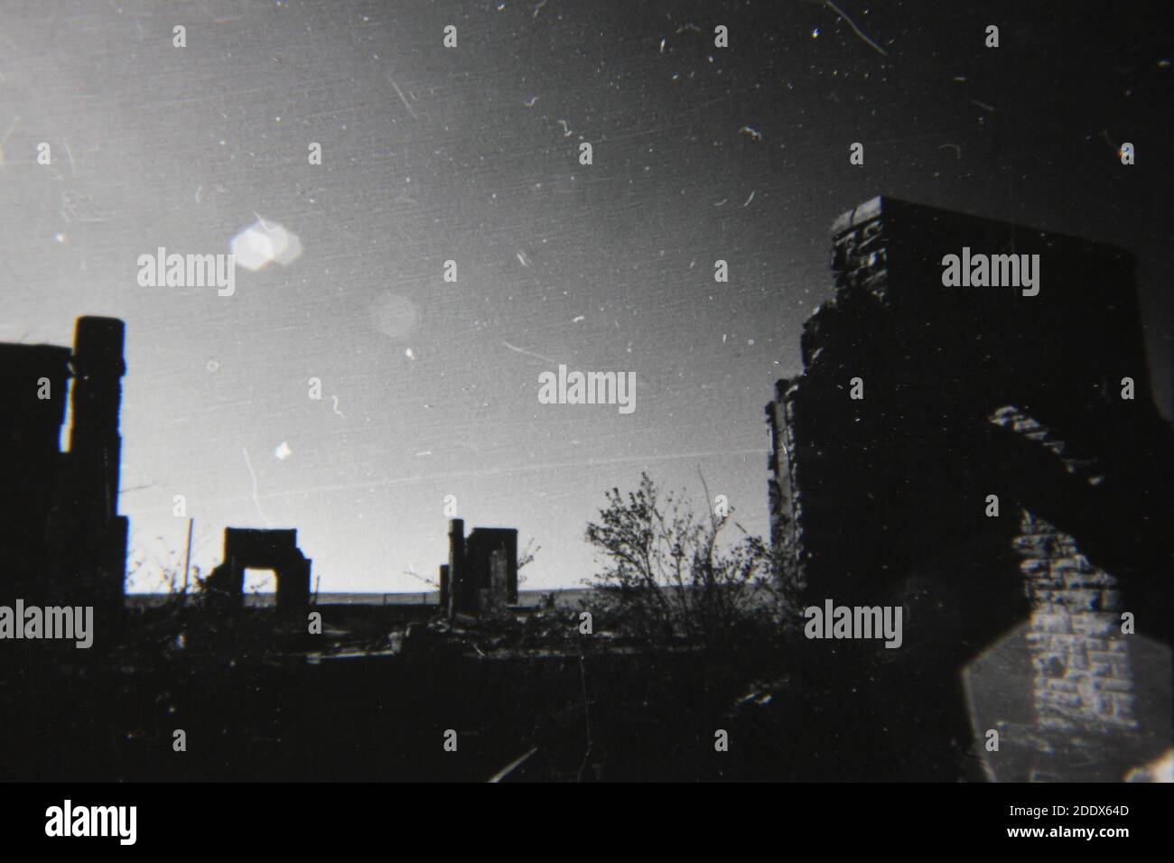 Feine Schwarz-Weiß-Fotografie der 1970er Jahre die verkohlten Überreste einer zerstörten Stadt. Stockfoto