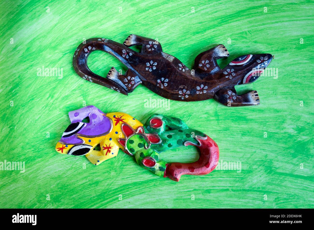 Farbige hölzerne Geckos Puppen' auf abstraktem Aquarell Hintergrund. Stockfoto