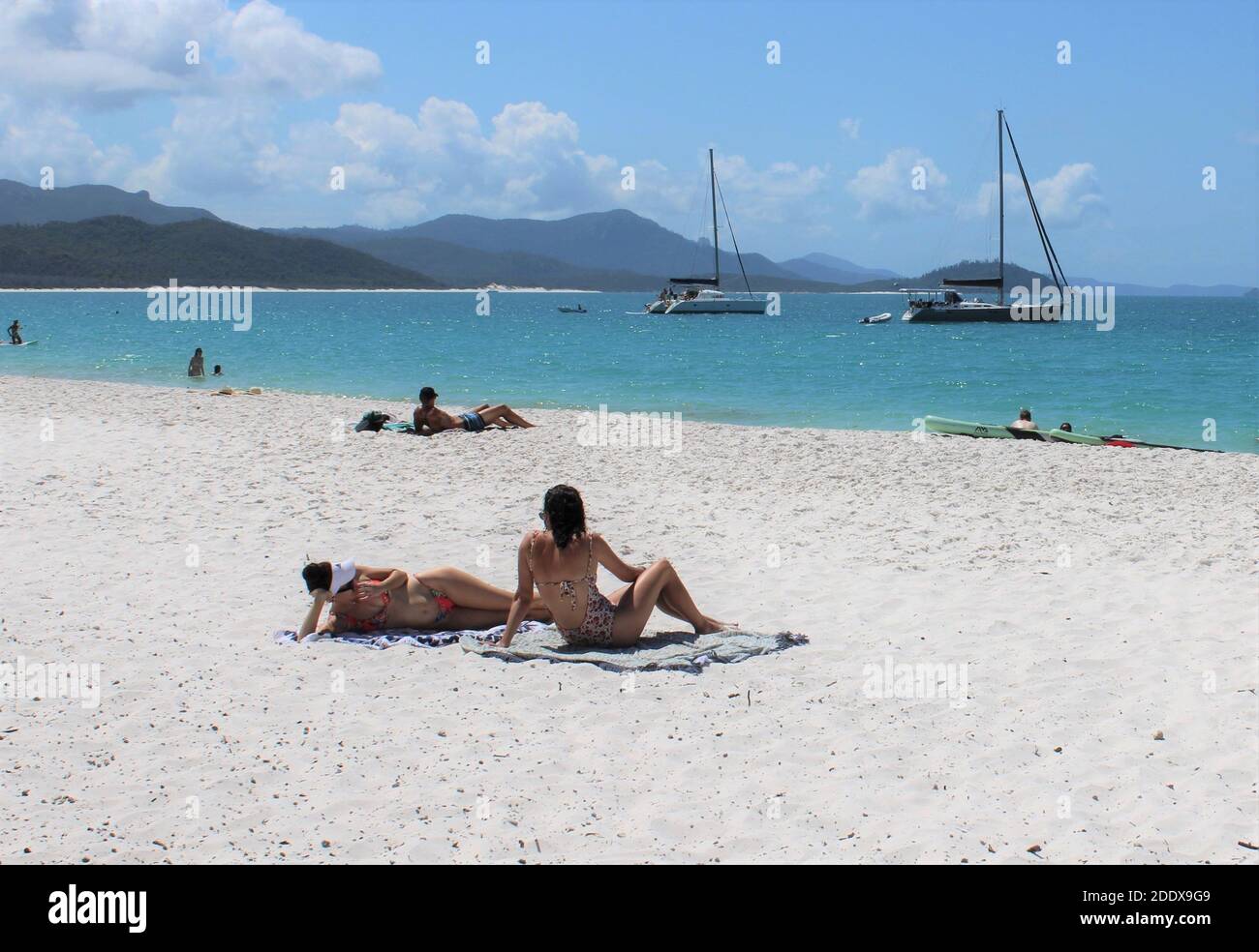 Leben im Freien in Australien, Sonnenanbeter am Whitehaven Beach, Whitsunday Island, Queensland, Australien. Stockfoto