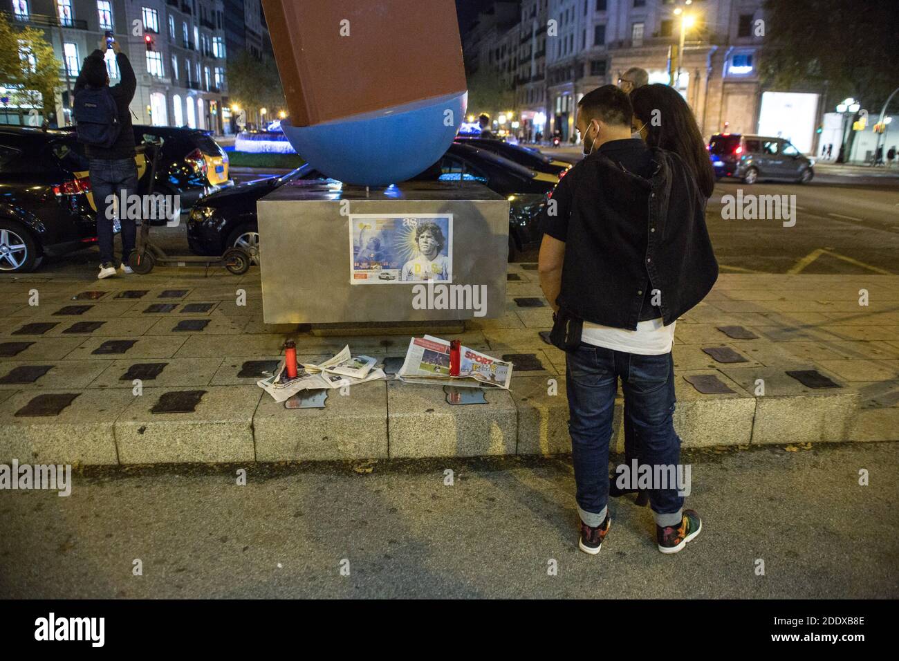 Barcelona, Spanien. November 2020. Das Paar sieht sich Maradonas Foto an. Der argentinische Fußballspieler Diego Armando Maradona starb am vergangenen Mittwoch. Kredit: SOPA Images Limited/Alamy Live Nachrichten Stockfoto