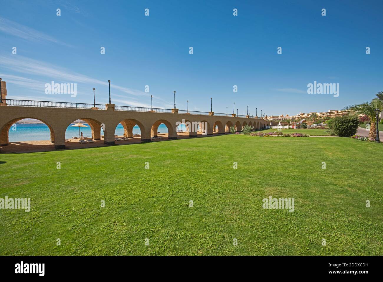 Blick über einen wunderschönen Landschaftsgarten in tropischem Resort mit Große Brücke und Torbögen am Strand Stockfoto