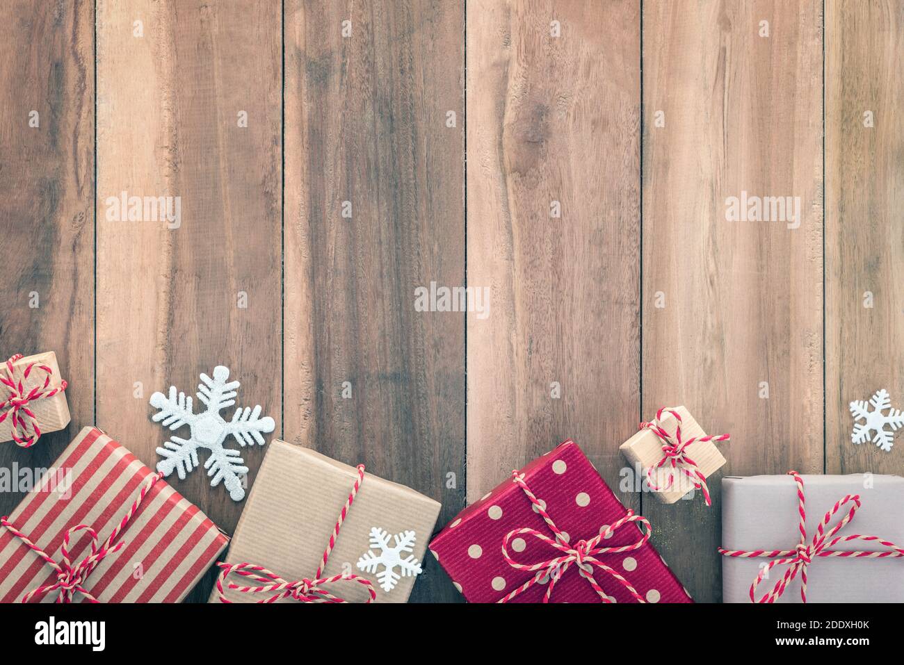 Geschenkschachteln und Weihnachtsschmuck, Bordüre, auf Holztafel Stockfoto