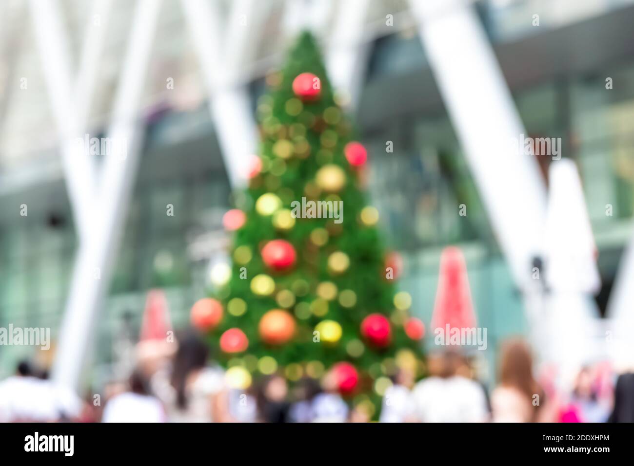 Verschwommenes Bild von im Freien bunt geschmückten Weihnachtsbaum mit Menschen In der Weihnachtszeit vor dem Einkaufszentrum Stockfoto