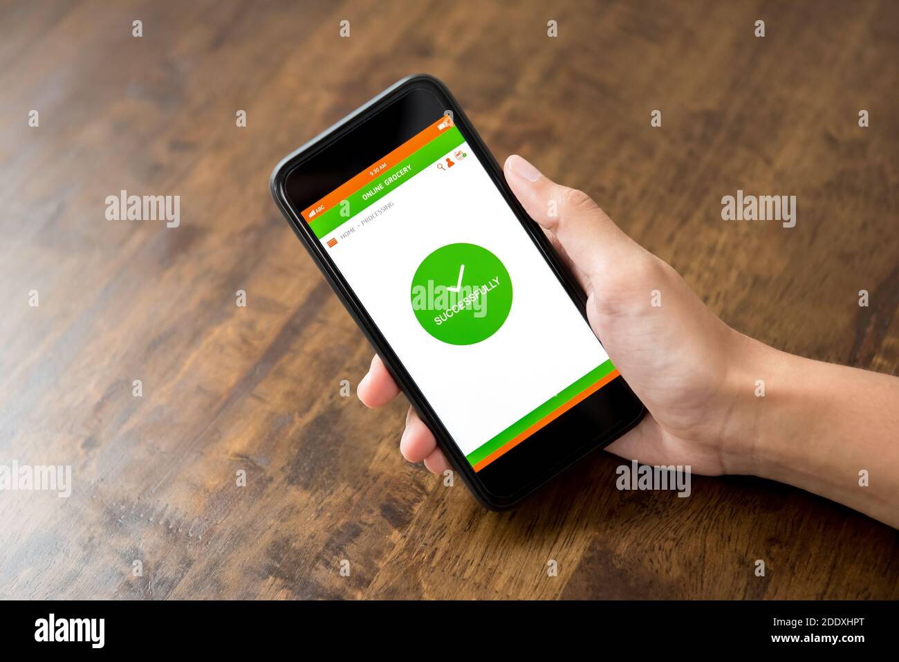 Hand halten Smartphone zeigt erfolgreich Text auf dem Bildschirm bestätigt online Lebensmitteleinkauf über Anwendung zu Hause Stockfoto