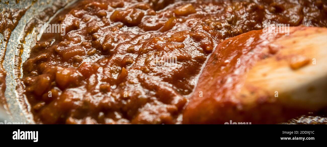 Hausgemachte köstliche italienische Bolognese Spaghetti-Sauce mit Rindfleisch Hackfleisch in der Pfanne gekocht, Panorama-Banner Stockfoto Hausgemachte köstliche italienische Bolognese Spaghetti-Sauce mit Rindfleisch Hackfleisch in der Pfanne gekocht, Panorama-Banner Stockfoto