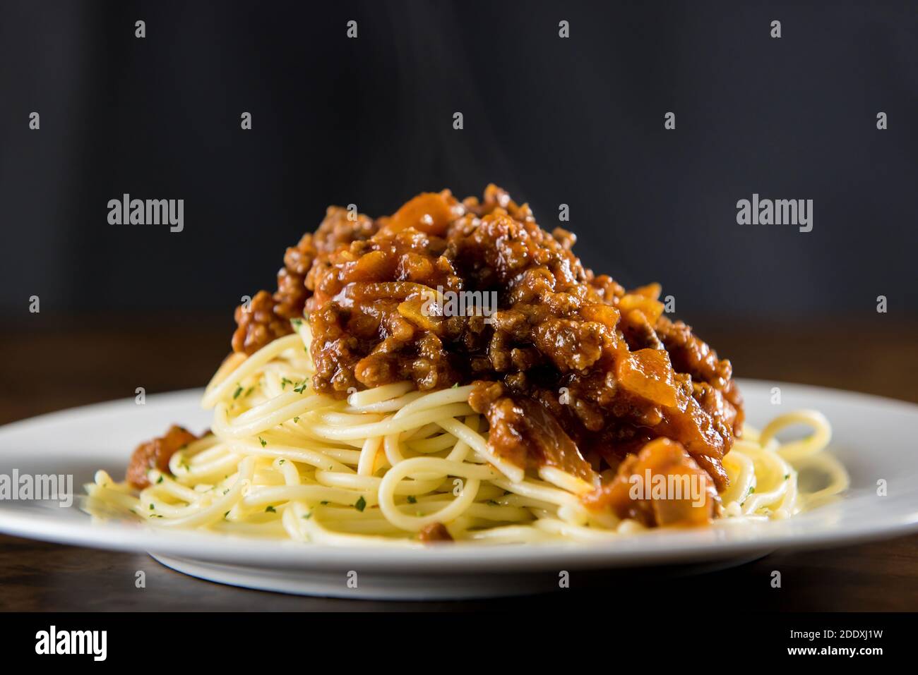 Hausgemachte leckere italienische Spaghetti mit heißen Bolognese Fleisch Sauce in Weiße Platte auf dem Tisch Stockfoto