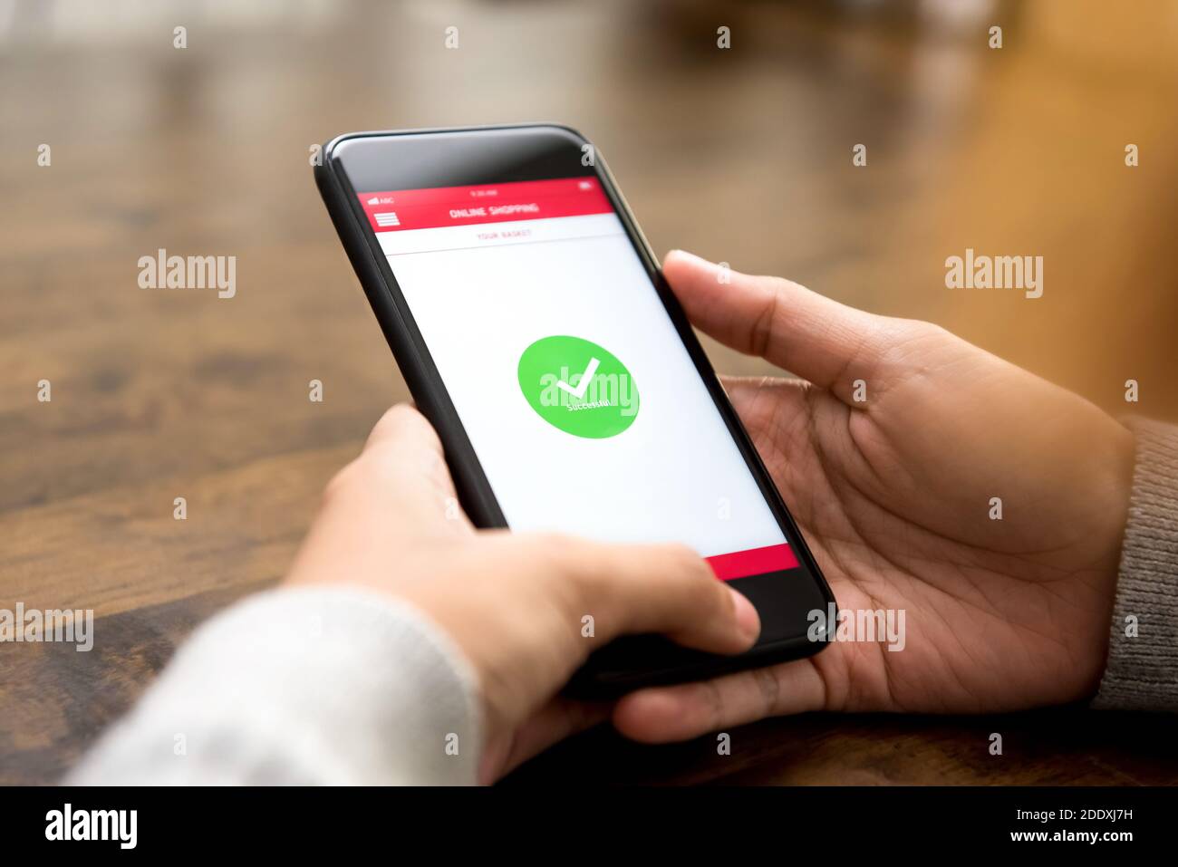 Das Bestätigungszeichen für den erfolgreichen Online-Einkauf erscheint danach auf dem Smartphone-Bildschirm Digitale Bezahlung durch eine Kundin Stockfoto