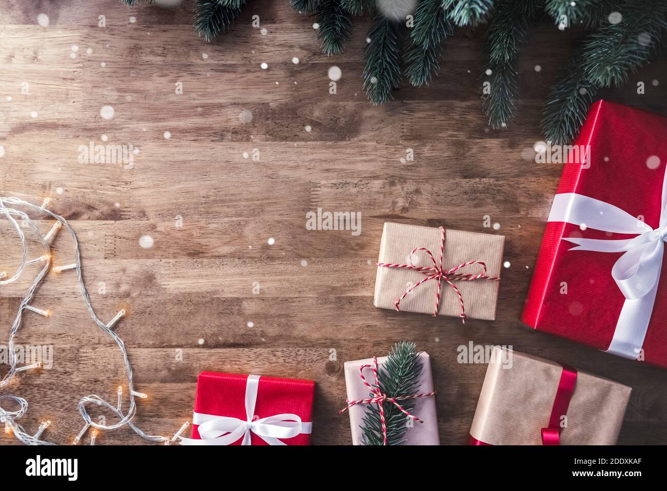 Weihnachten und Neujahr Hintergrund mit Geschenk-Boxen, String Licht und grünen Kiefer Dekorationen auf Holz Tisch Hintergrund, Draufsicht mit Coyp Raum Stockfoto