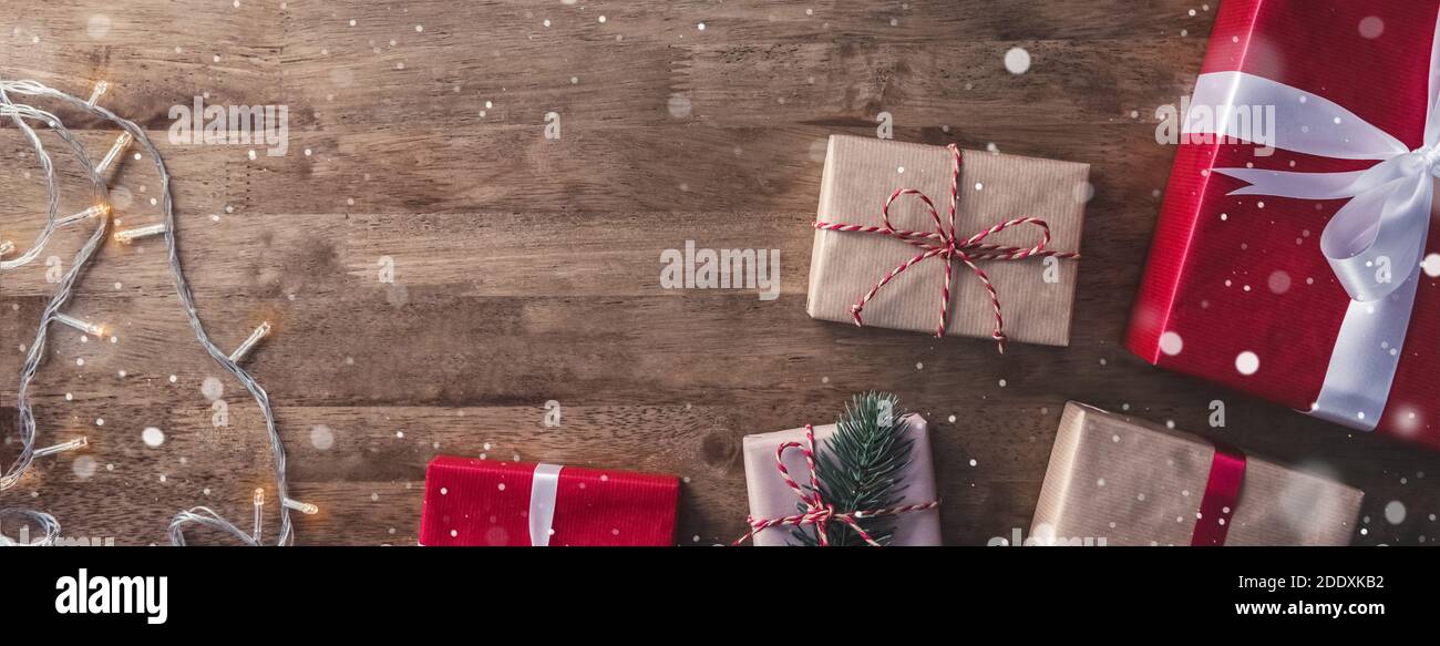 Weihnachten und Neujahr Hintergrund mit Geschenk-Boxen und String Licht Dekorationen auf Holz Banner Hintergrund, Draufsicht mit Copy Space Stockfoto