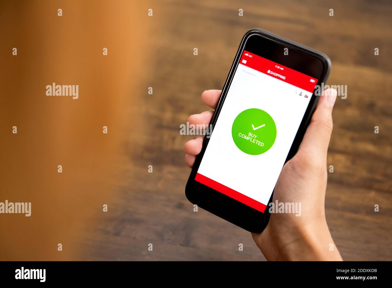 KAUFEN ABGESCHLOSSEN Zeichen erscheint im Smartphone Shopping-Anwendung Bildschirm nach Online-Zahlung durch eine Kundin Stockfoto