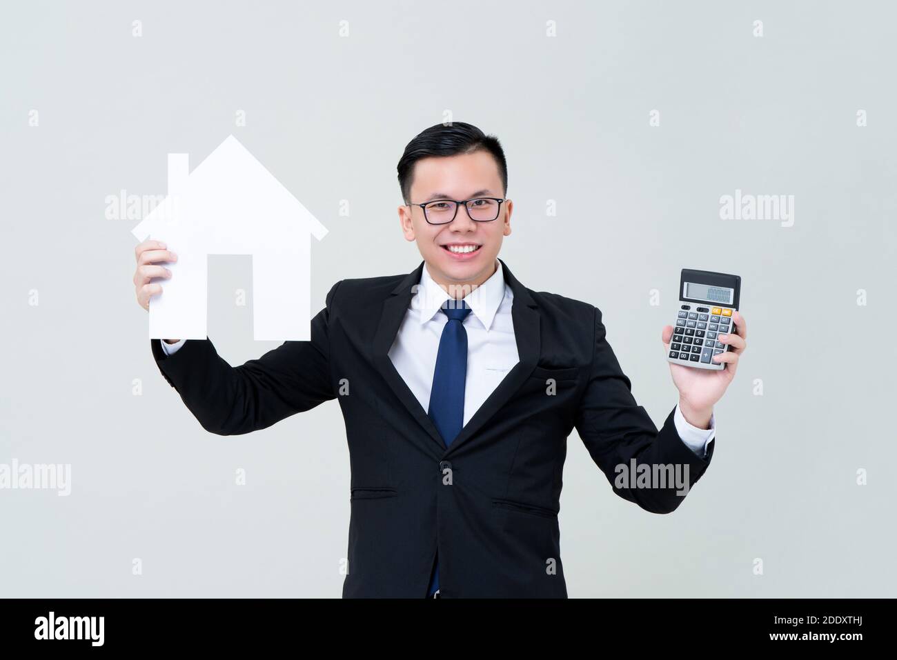 Asiatische Mann Agent zeigt Haus Modell mit Rechner für real Immobilienfinanzierung und Investitionskonzept Stockfoto