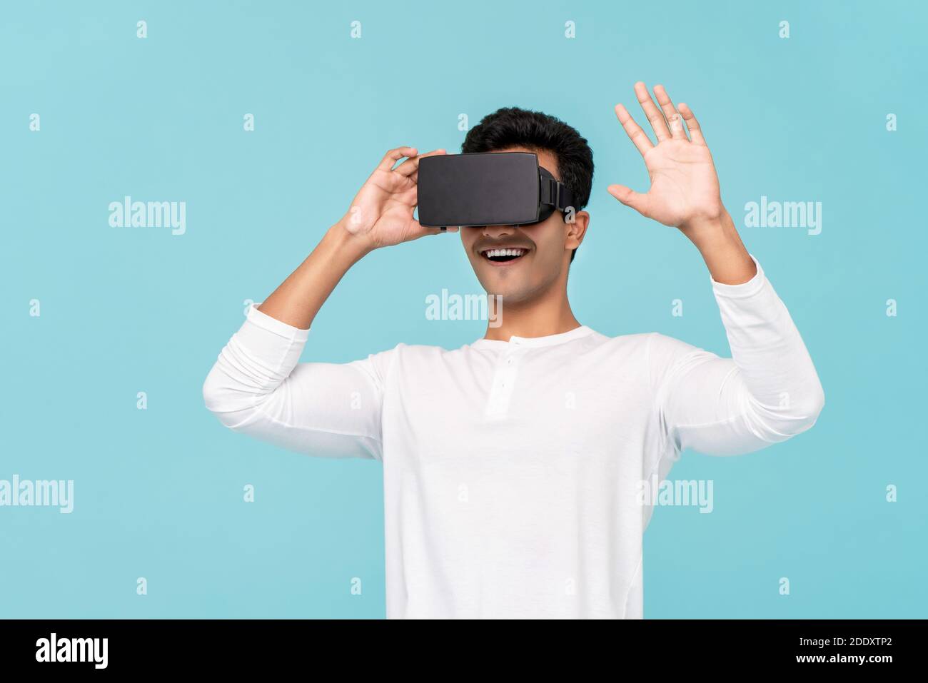 Aufgeregt asiatischen Mann genießen 3D-Simulation Video von virtuellen Reality oder VR Brille auf hellblauem Hintergrund Stockfoto