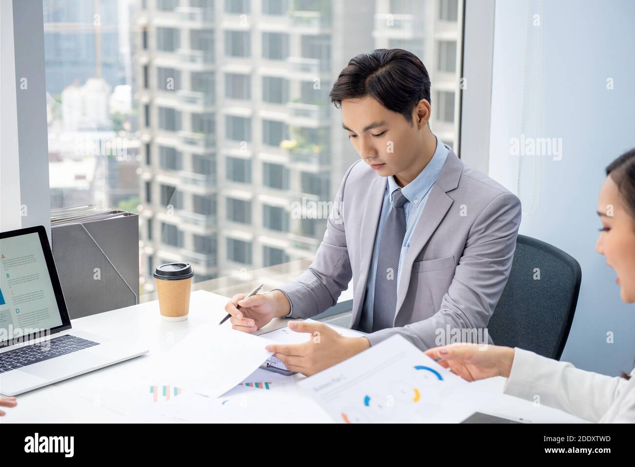 Junger asiatischer Geschäftsmann konzentriert sich auf das Lesen Dokument in der Sitzung Im Büro in der Stadt Stockfoto