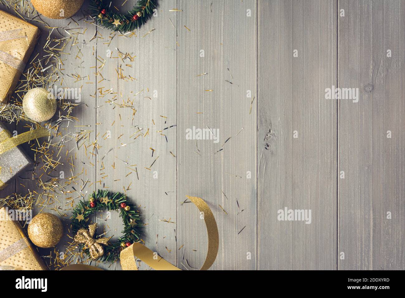 Draufsicht auf Weihnachtsgeschenkschachteln und Gold dekorieren Artikel Wie Rüschen Bänder und Mistelkränze neben Copy Platz auf Holzhintergrund Stockfoto