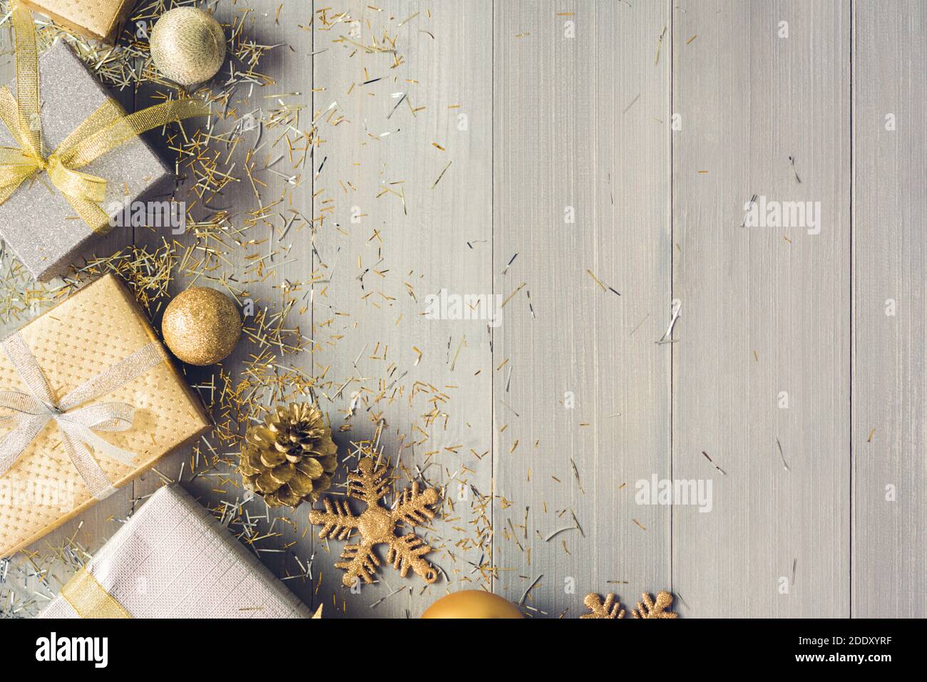 Draufsicht auf Weihnachten Geschenk-Boxen mit Bändern gebunden und Gold Dekoration Artikel wie Schneeflocken und Kiefernnadeln neben Kopie Raum auf Holz Hintergrund Stockfoto