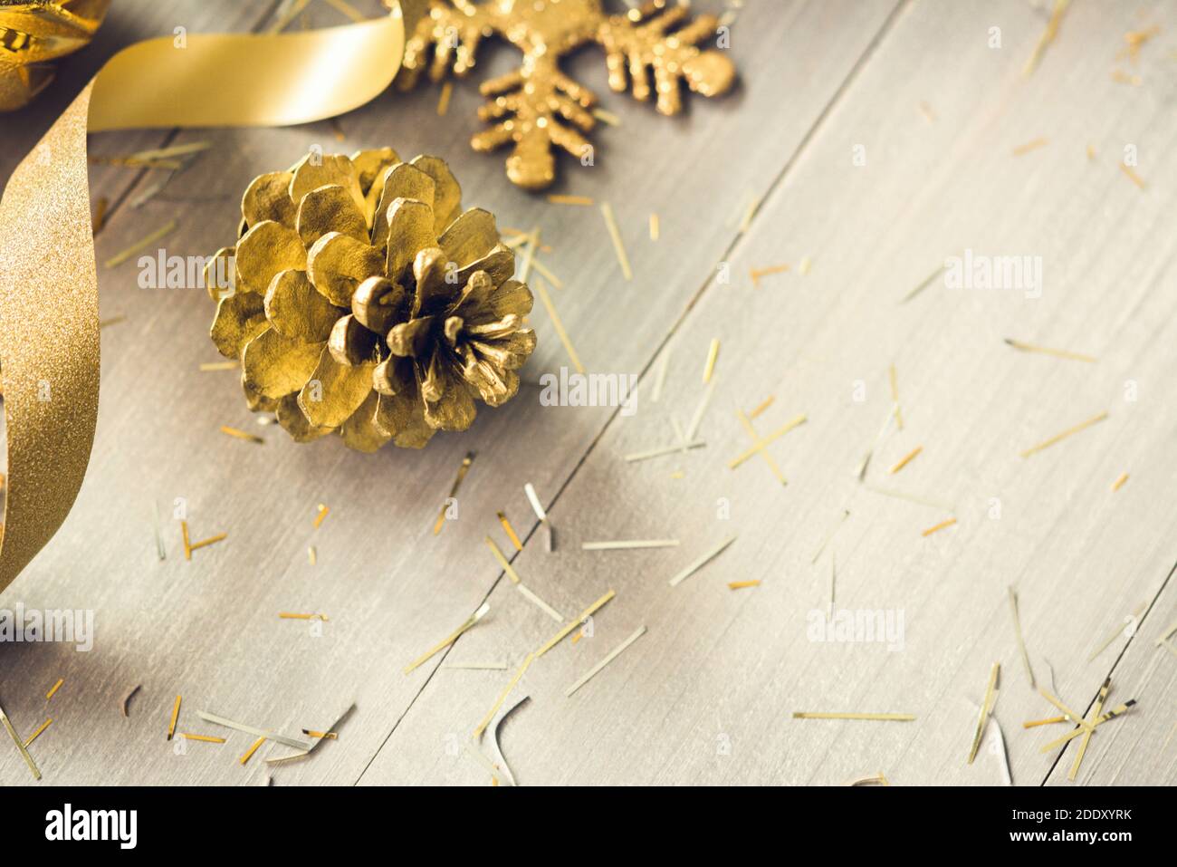 Goldenes Glitzer-Lockenband und Weihnachtsschmuck auf Holz Hintergrund mit Kopierbereich Stockfoto